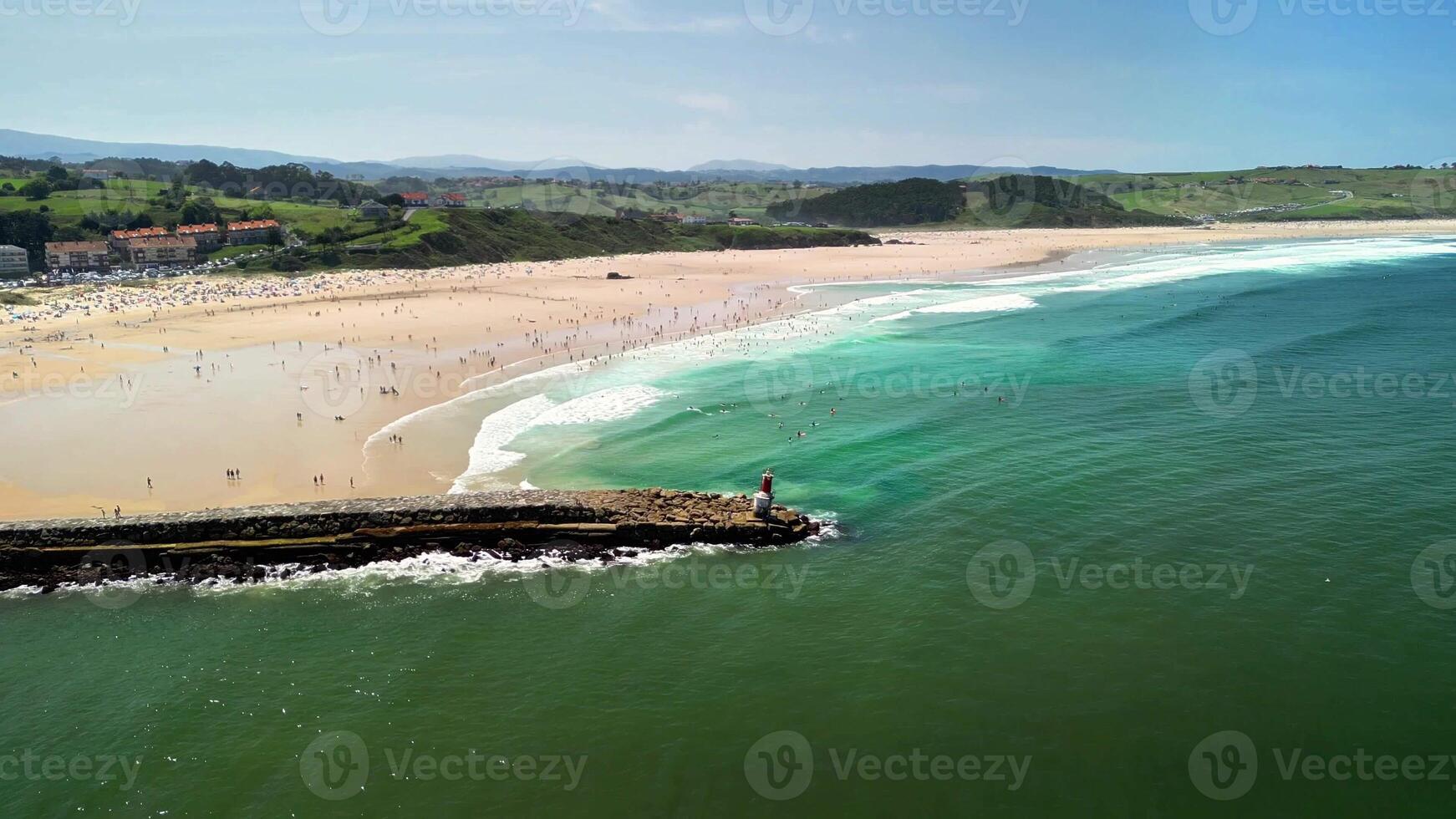 Enjoy a stunning aerial view of a pristine beach with crashing waves and sunbathers on warm, golden sand photo
