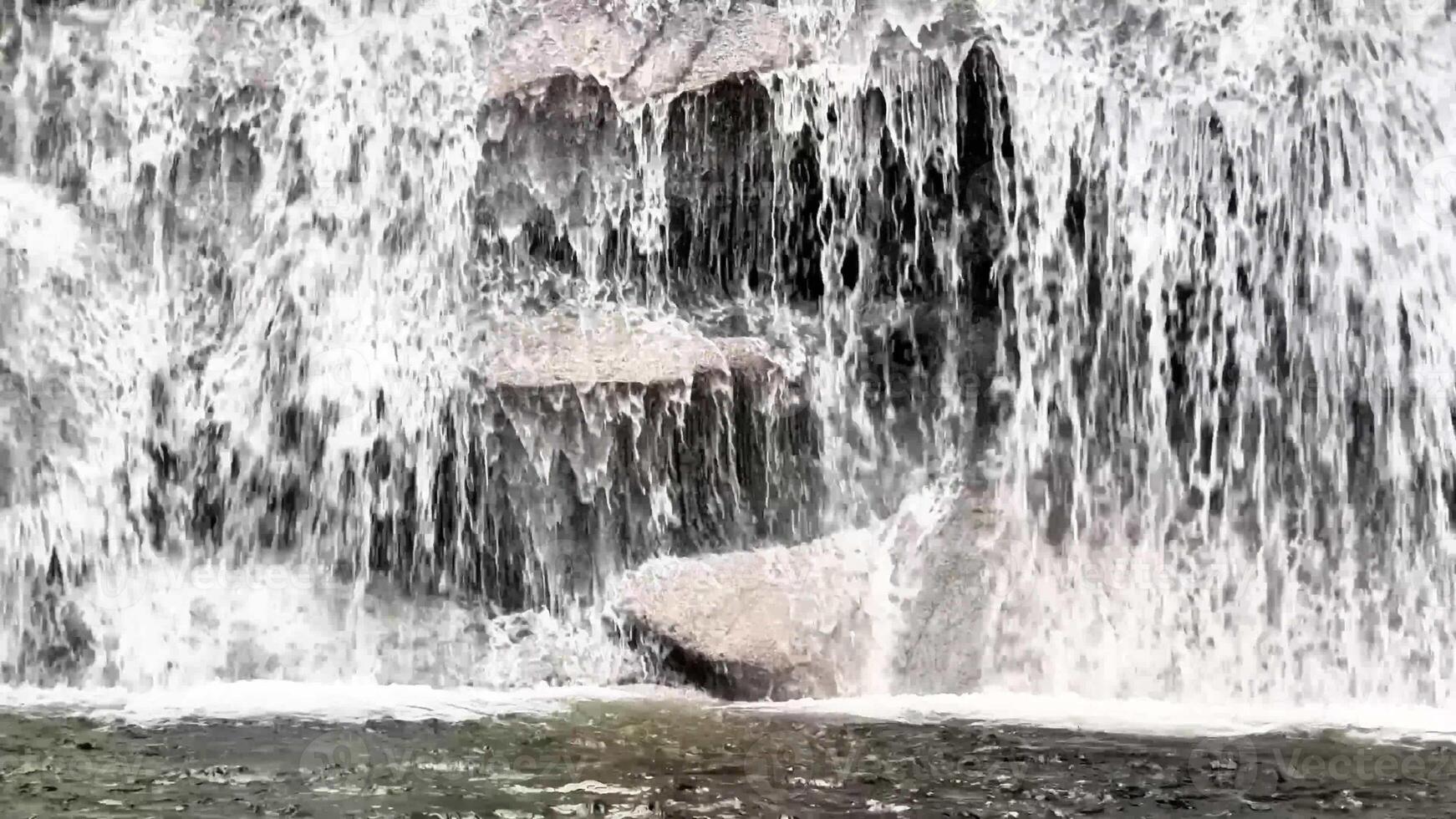 A serene and tranquil view of cascading water flowing gracefully over rocks, capturing the pure beauty of natures flow photo