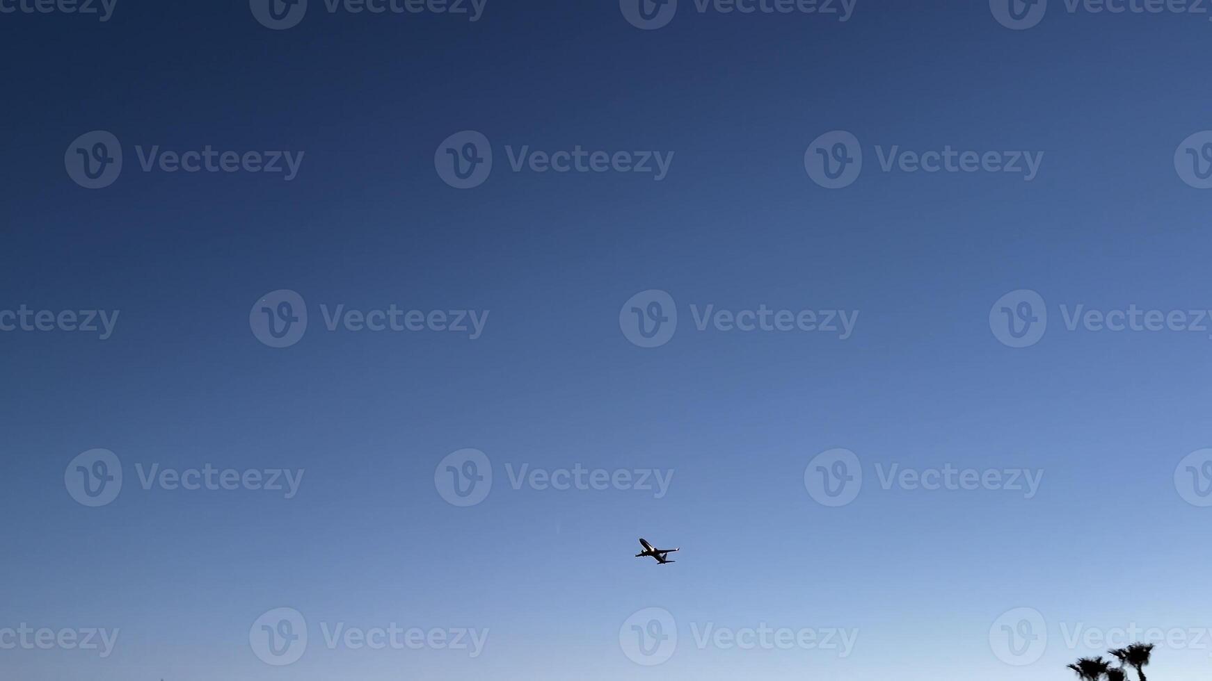 A majestic airplane soars through the bright blue sky, embodying the essence of travel, exploration, and adventure photo