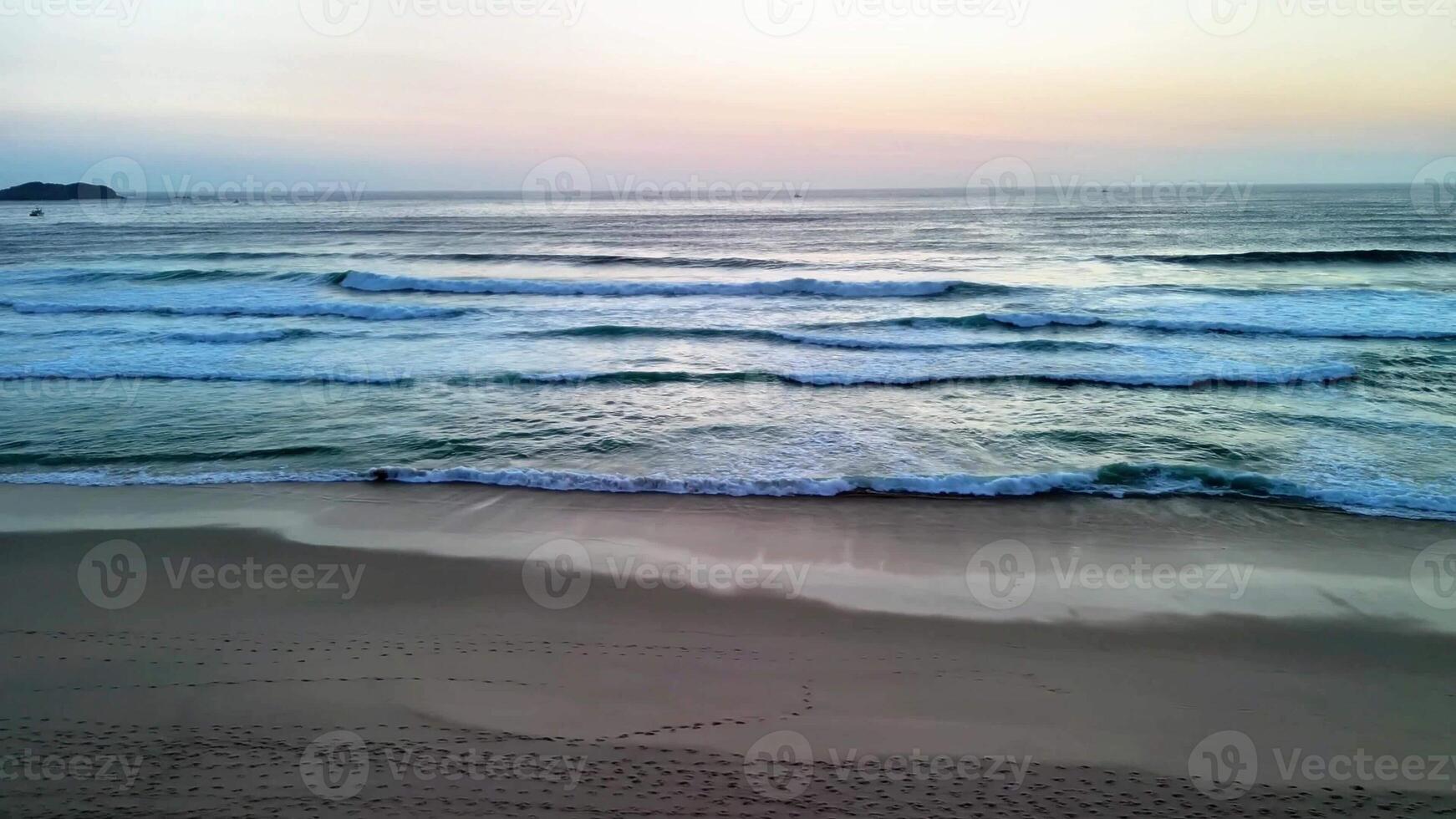 A peaceful view of soft waves lapping on the shore at sunrise, creating a calming beachfront atmosphere. photo