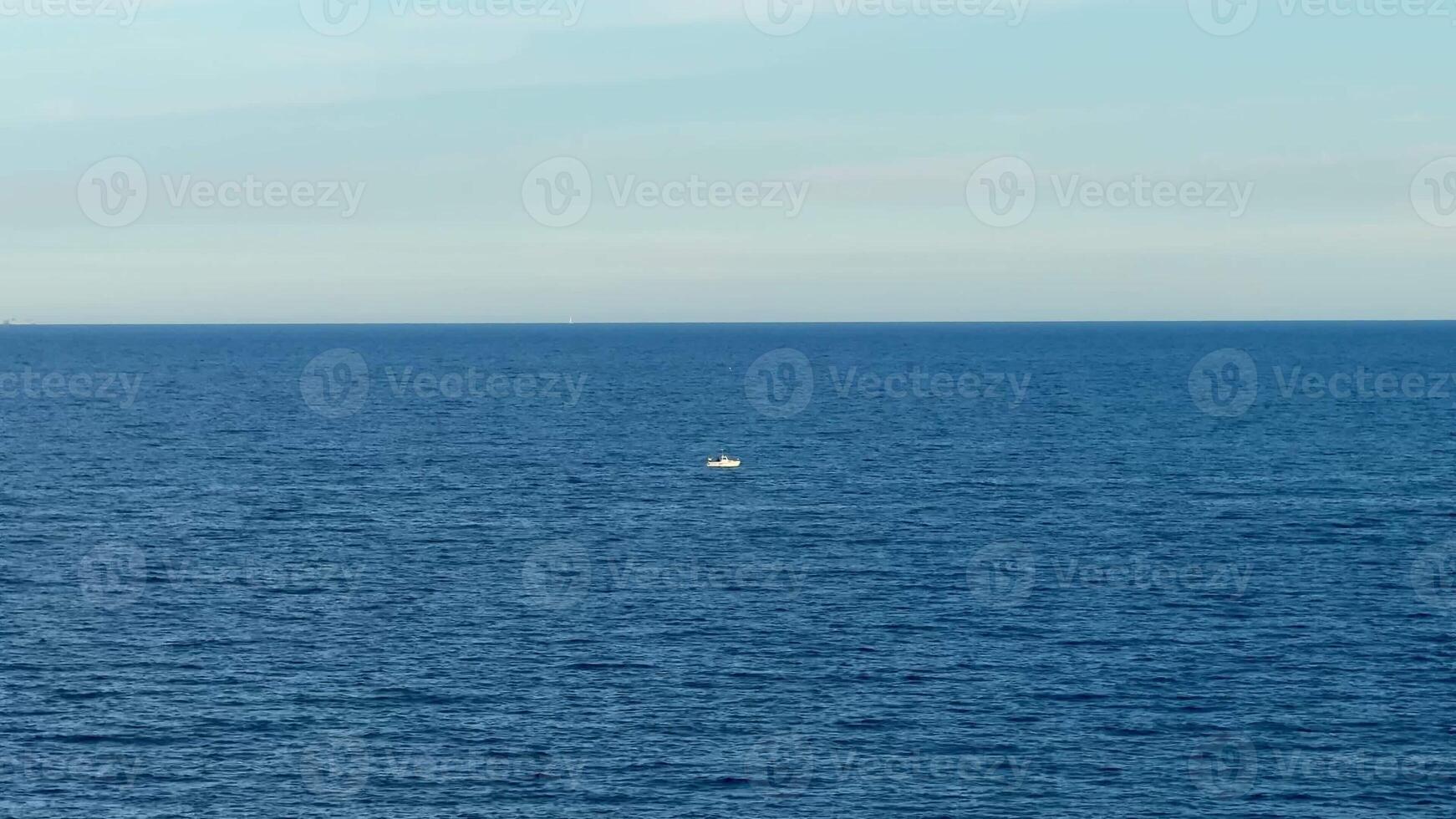 A peaceful and tranquil view of the vast ocean, showcasing a small boat, perfectly capturing natures stunning beauty photo