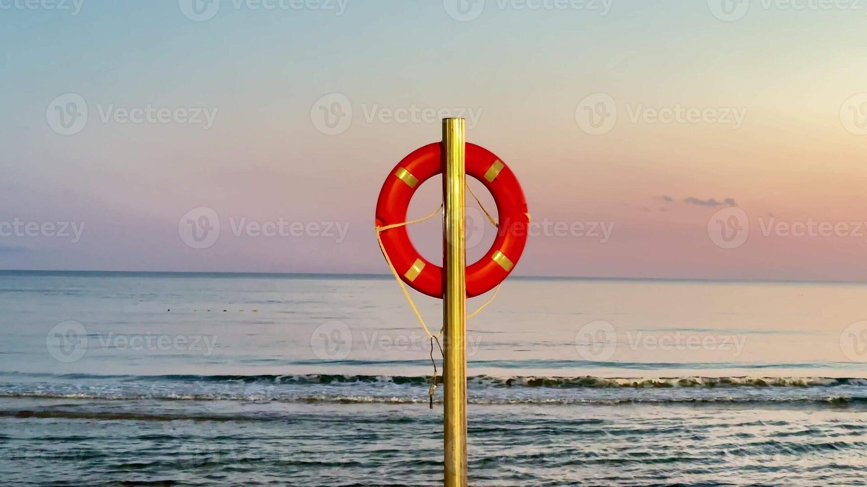 A breathtaking and picturesque sunset unfolds at the serene beach, showcasing a vibrant lifebuoy on display photo