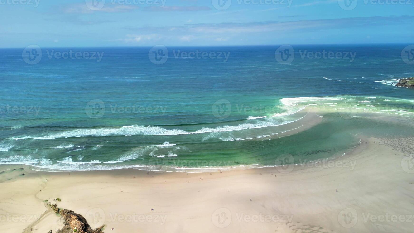 An aerial view showcases the serene and stunning beauty of a picturesque beach along with its calming rolling waves photo