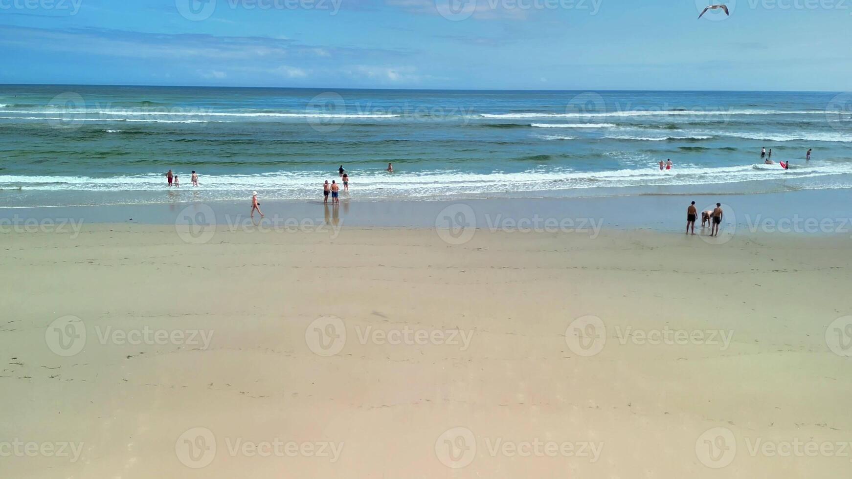 Enjoy a wonderfully serene beach scene that features gentle waves lapping at the shore and sunbathers relaxing photo