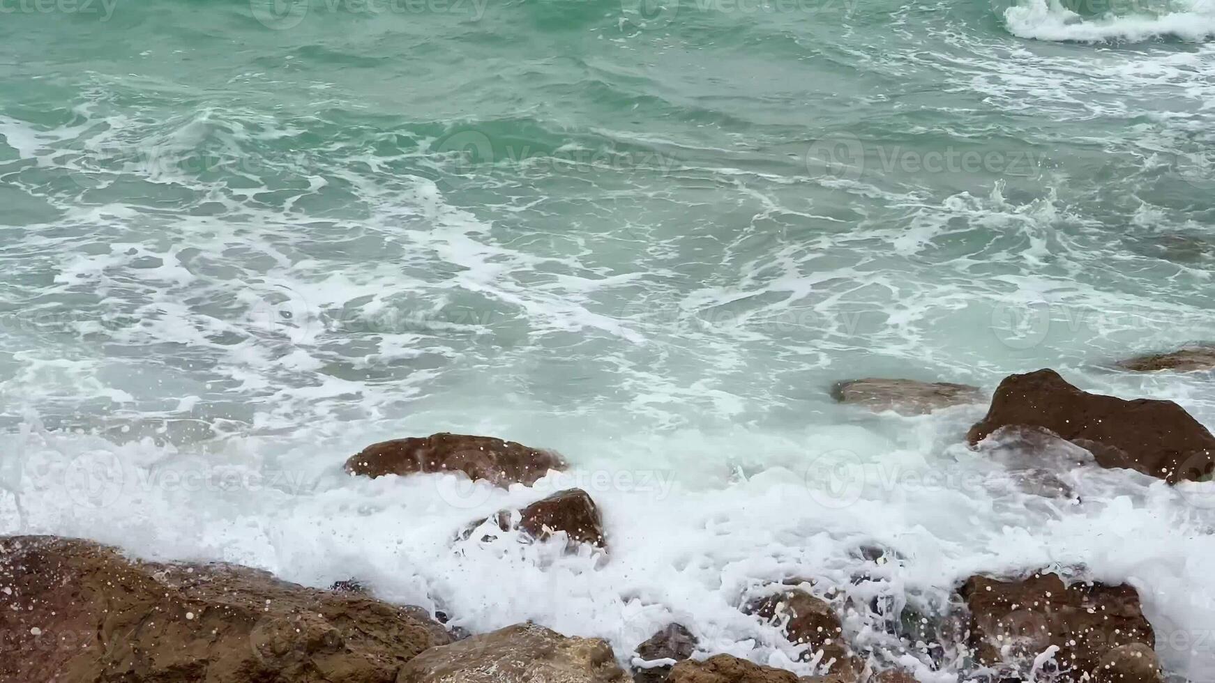Serene, gentle waves repeatedly wash over the rugged coastal rocks in a beautifully tranquil seascape setting photo