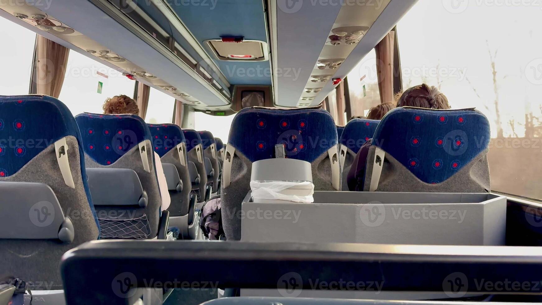 A spacious and inviting interior of a modern bus, showcasing comfortable seating and a sunny, cheerful ambiance photo
