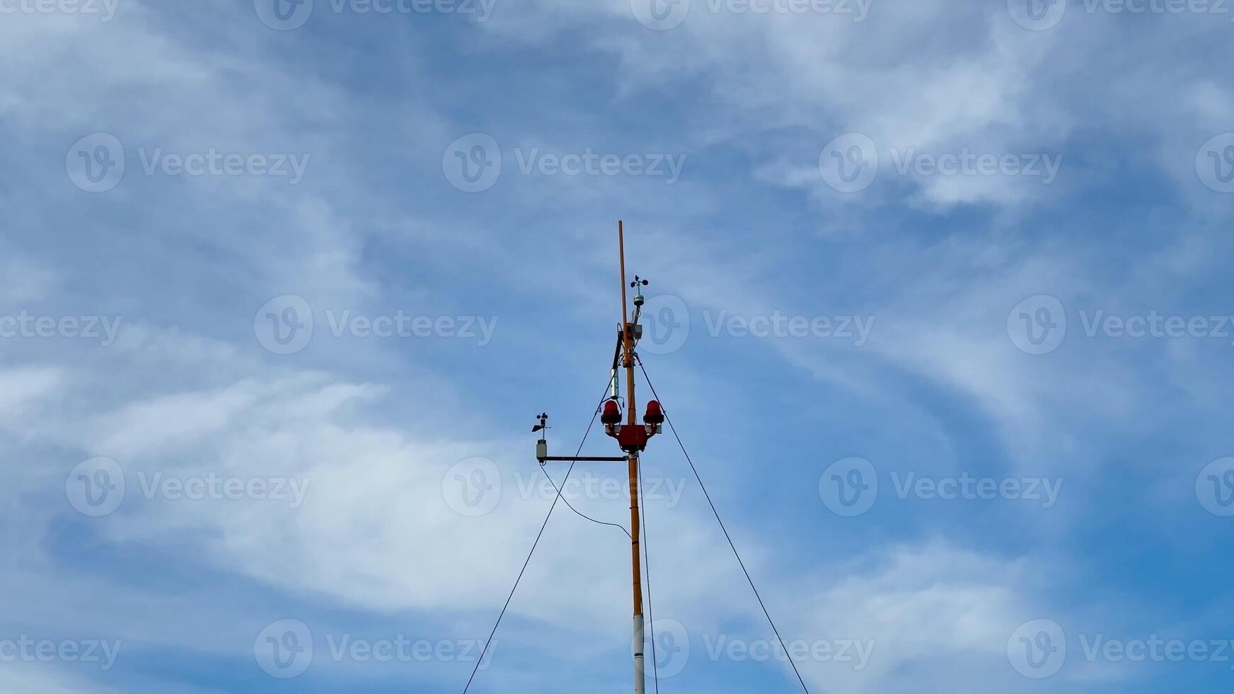 A dedicated worker can be seen performing vital maintenance atop a tall communication tower under a clear blue sky photo