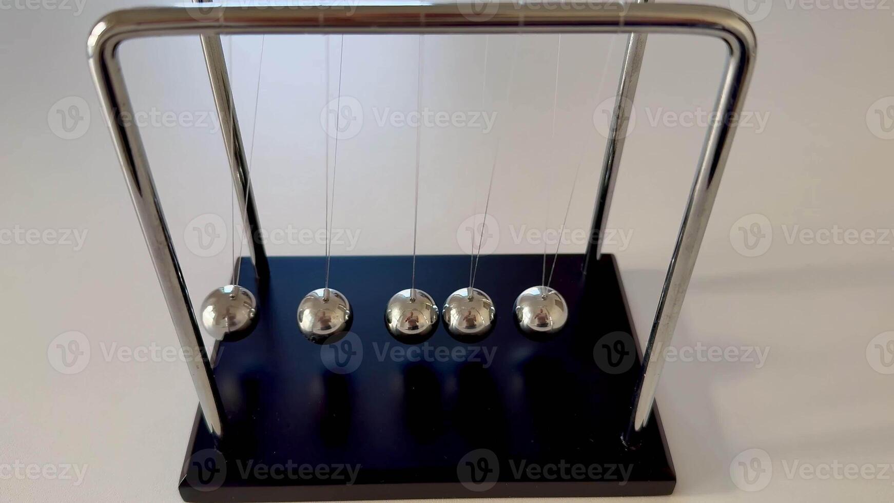 A classic Newtons Cradle elegantly showcasing the fascinating principles of momentum and energy transfer in action photo