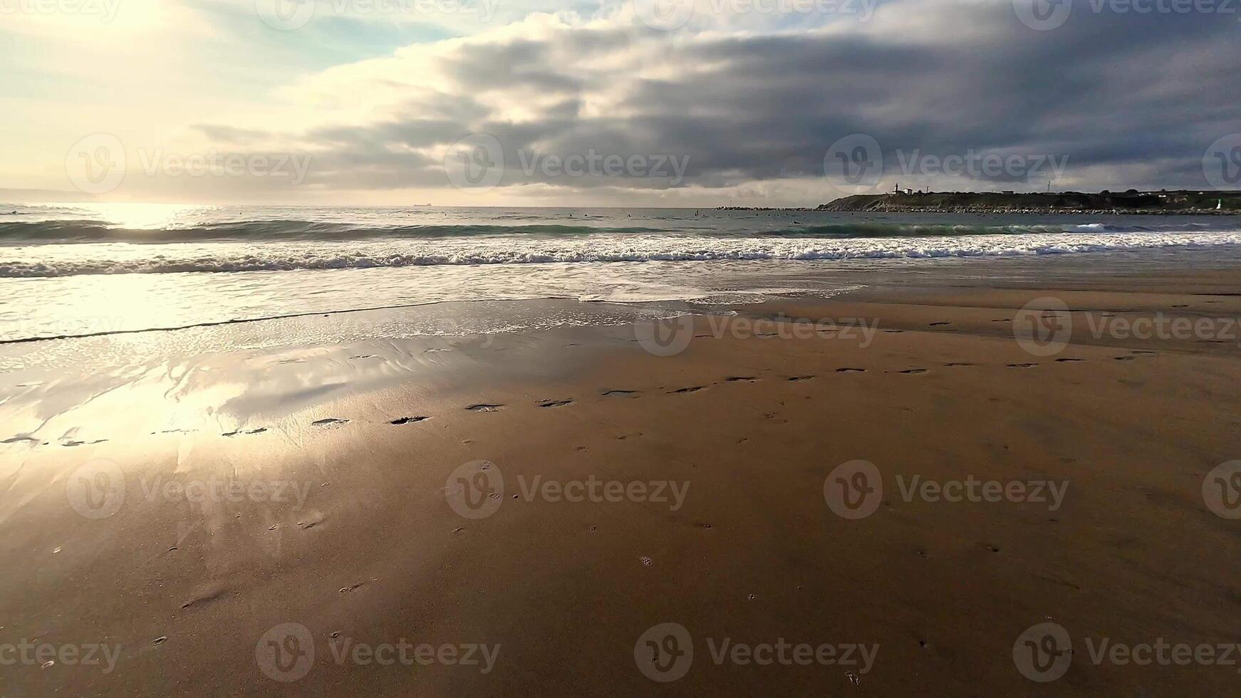 A tranquil beach scene featuring soft waves and footsteps in the sand, perfect for relaxation themes. photo