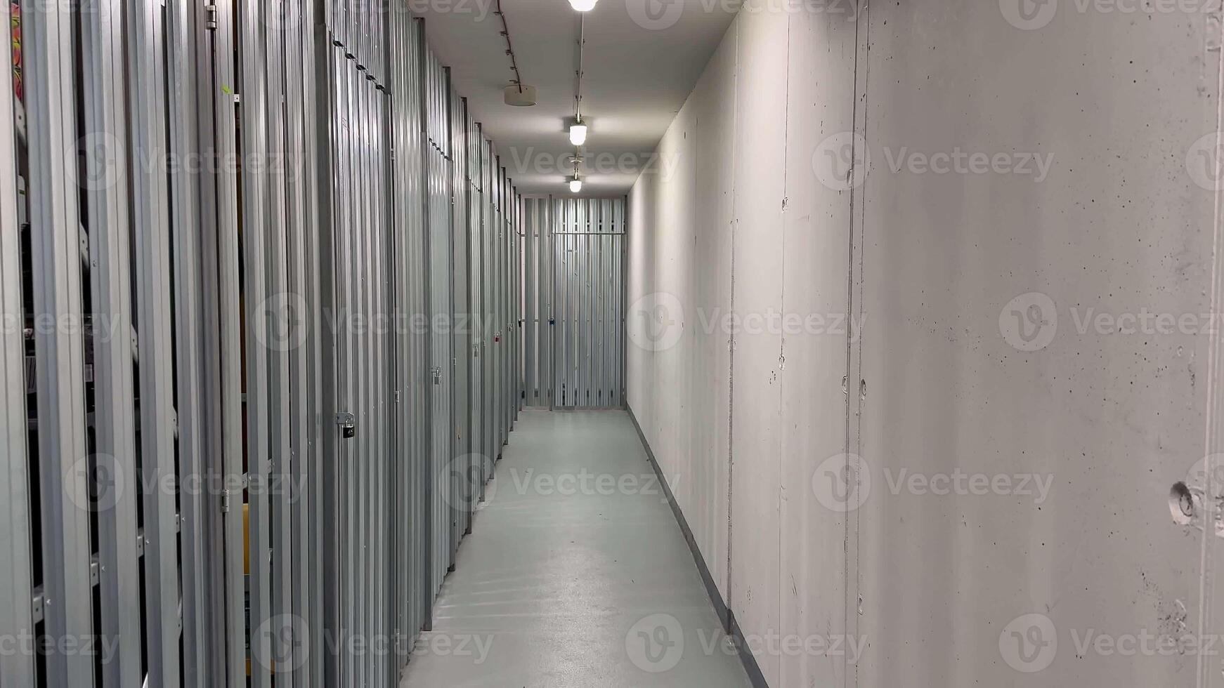 The clean, welllit hallway includes secured storage units in a large facility, ensuring your belongings safety photo