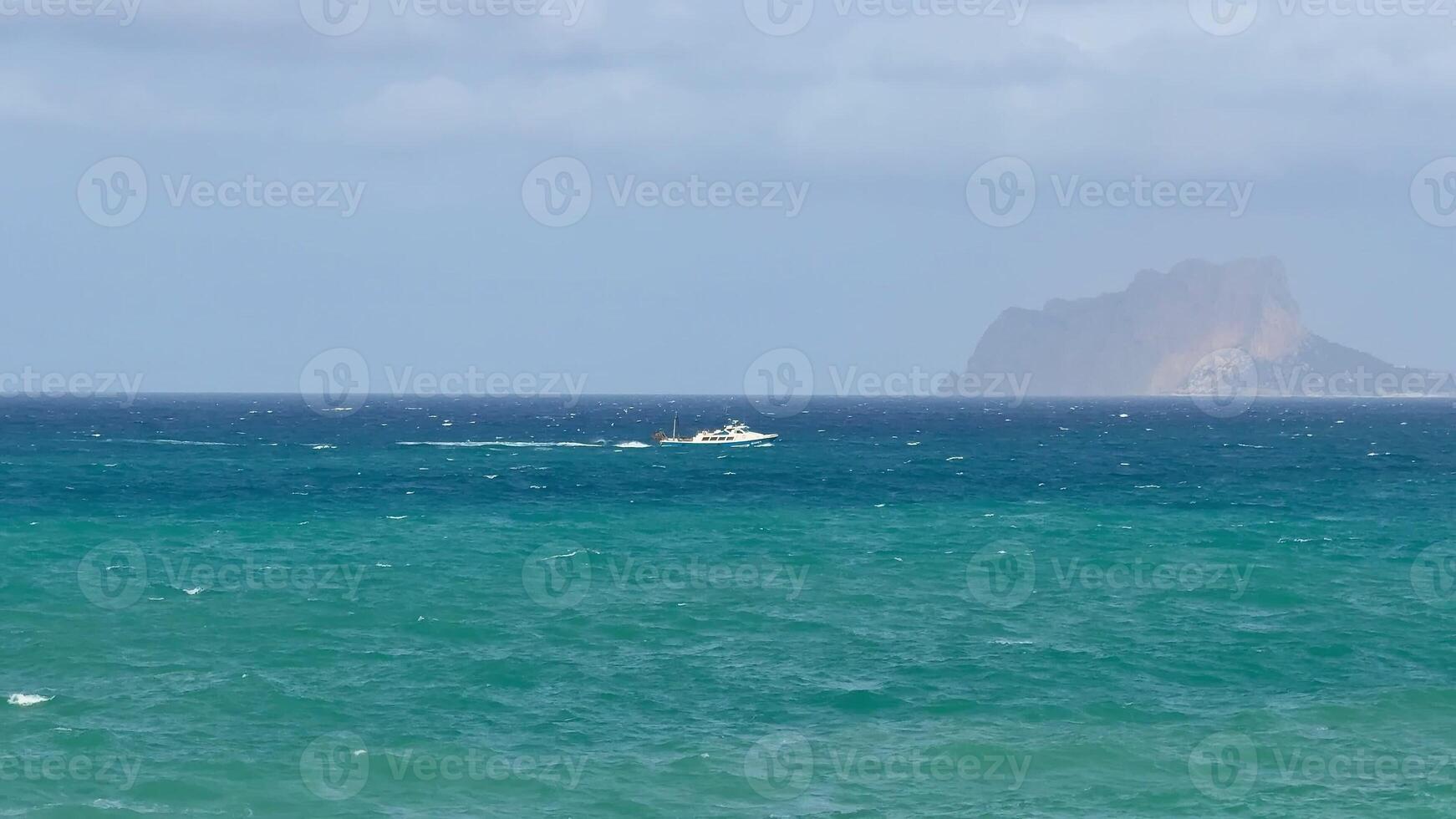 A beautifully crafted boat gracefully sails over a vibrant and colorful seascape with a stunning island backdrop photo