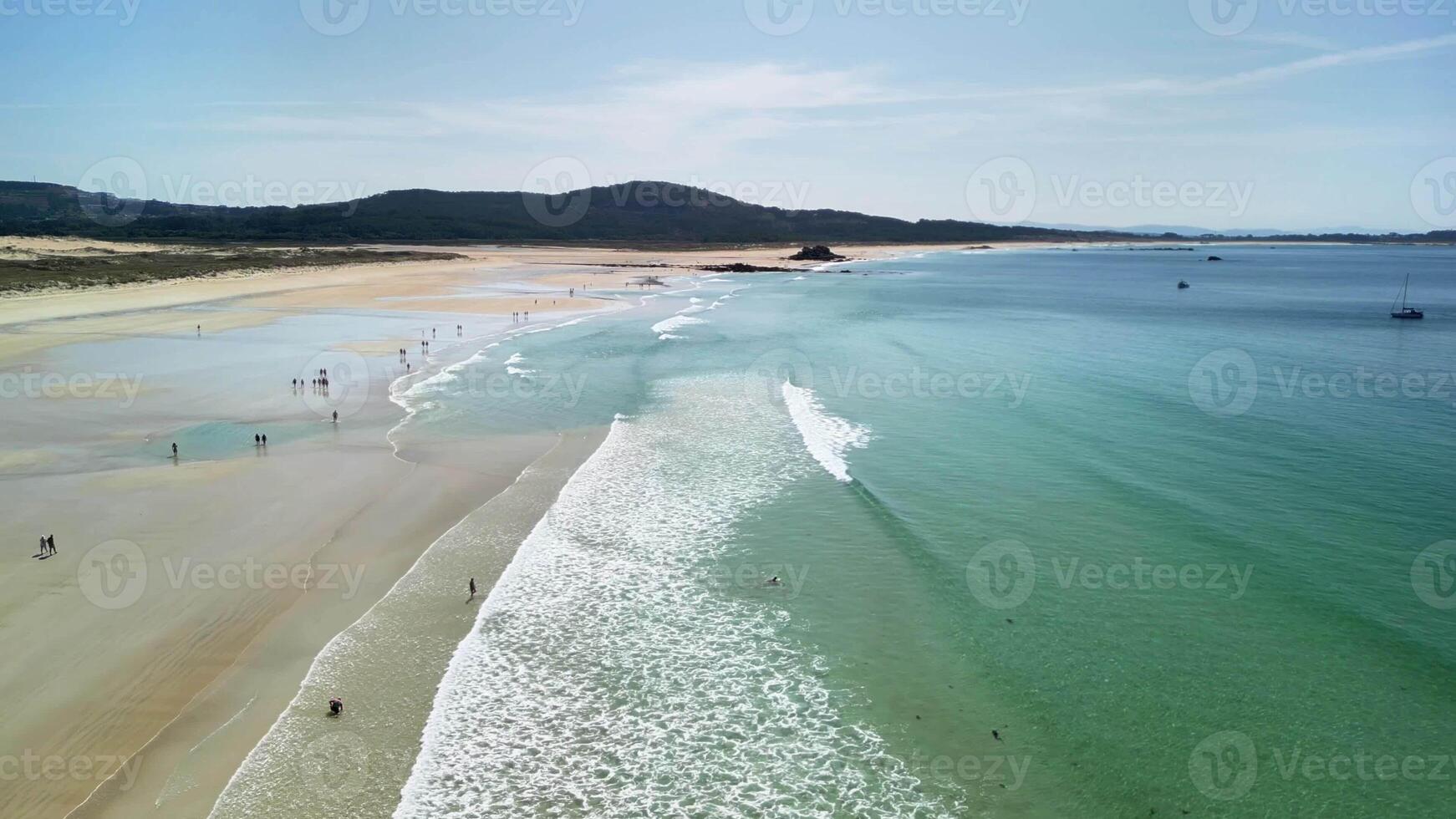 A stunning aerial view of a tranquil beach with clear turquoise waters and soft waves gently lapping the shore photo