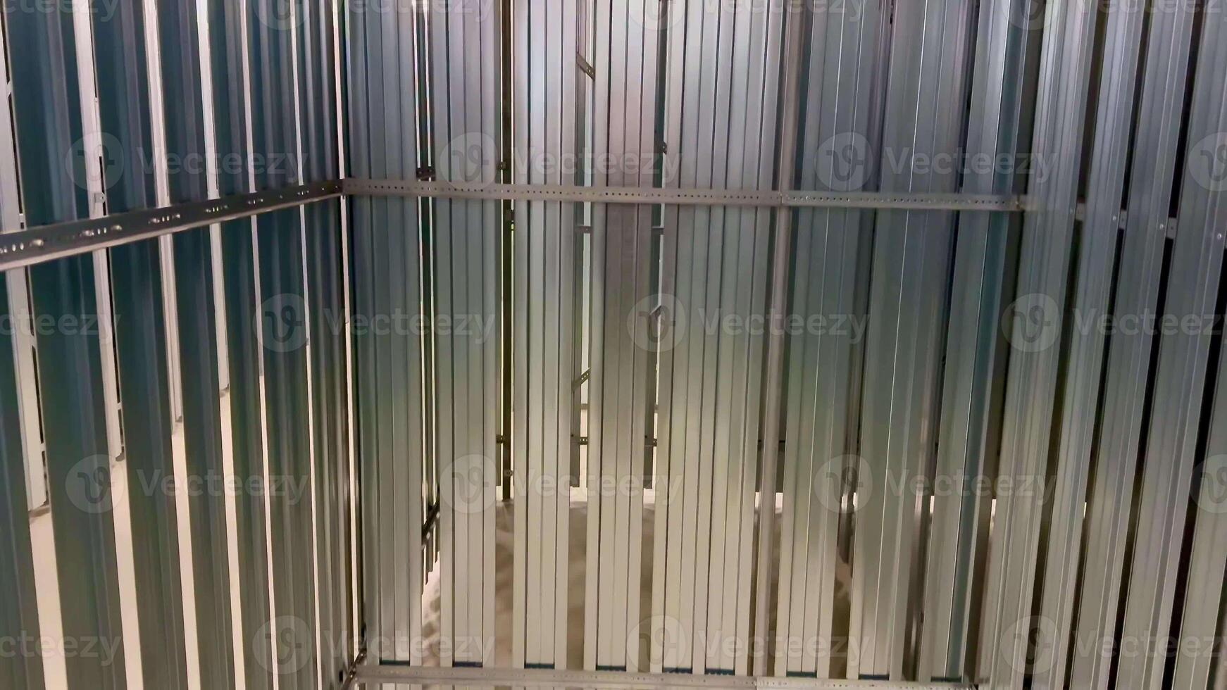 An interior view showcasing an empty metal storage container that features vertical metal slats throughout photo
