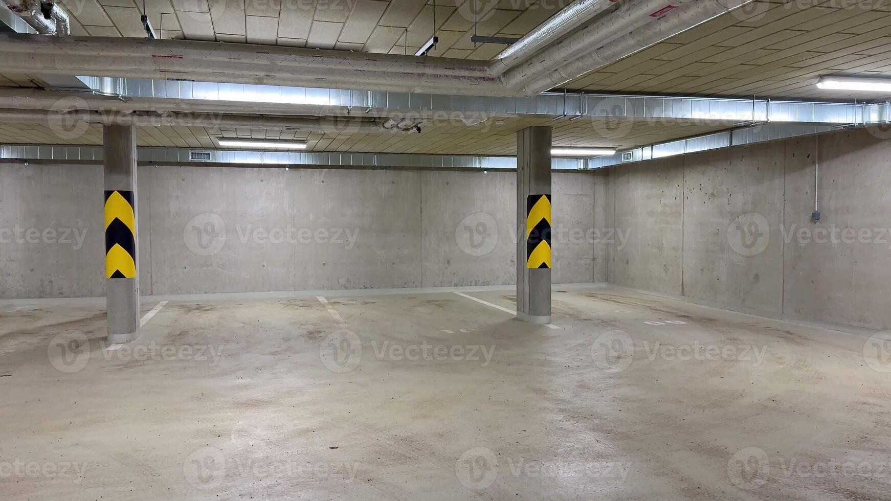 A comprehensive and detailed view of an underground parking garage showcasing ceiling infrastructure and piping systems photo