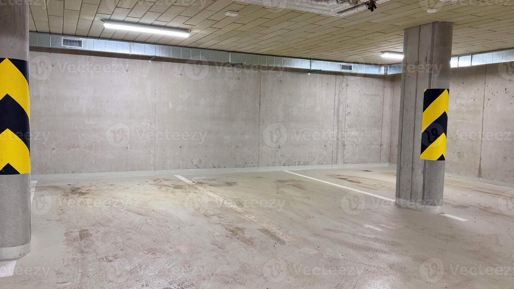 A clean, spacious parking garage with sturdy concrete walls and bold yellowblack safety markings for visibility photo