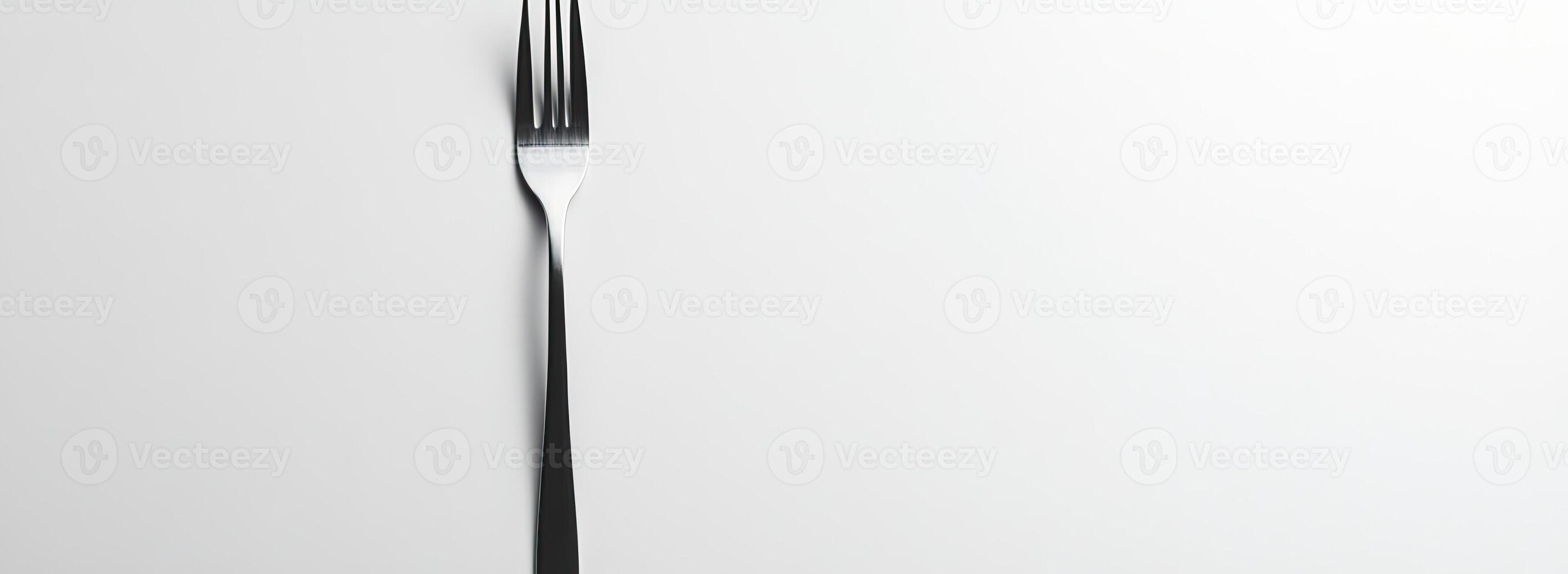 A single metallic fork on a white background photo
