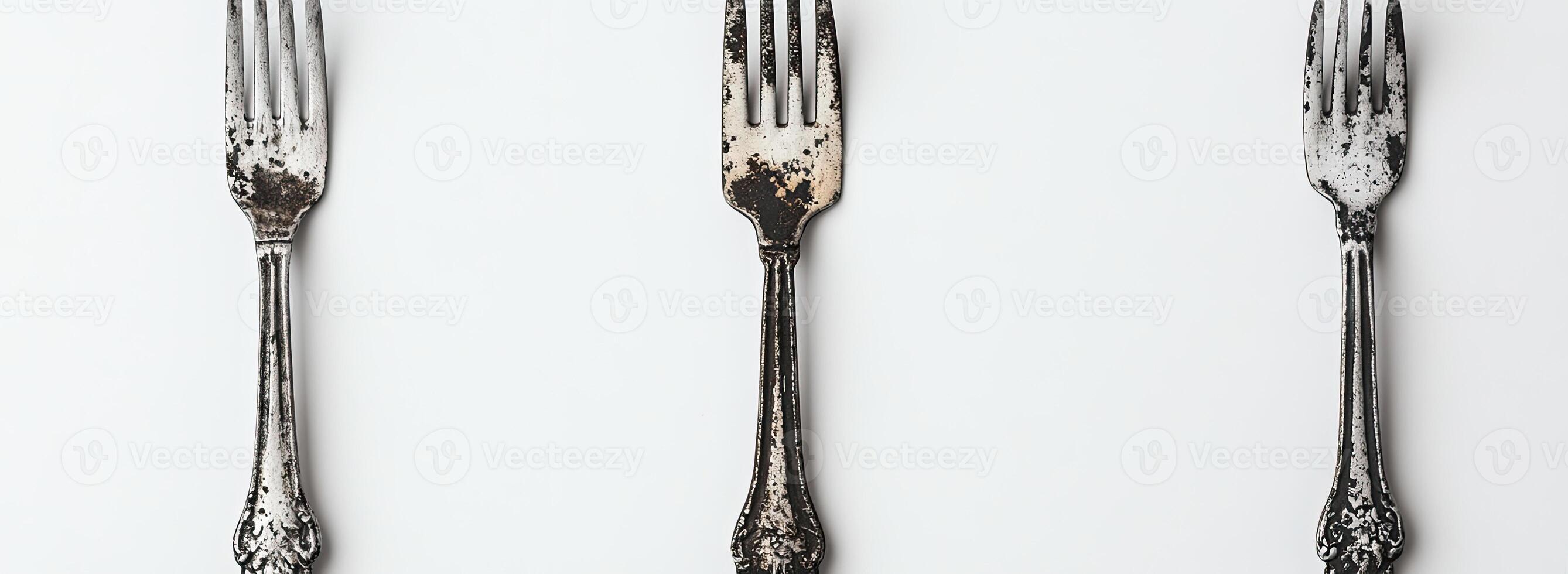 Three Antique Forks Arranged Vertically on White Background photo