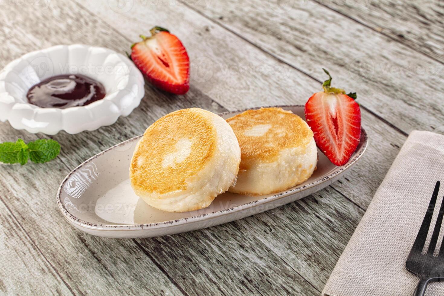 A plate with two pancakes and strawberries on it photo