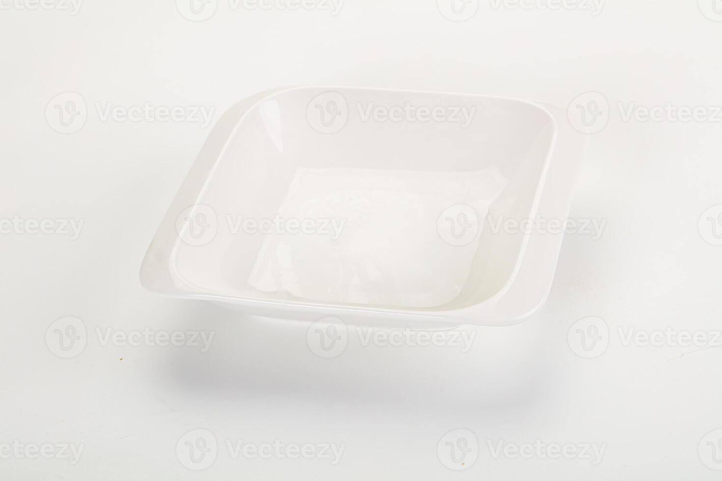 A white plastic bowl with a lid on a white surface photo