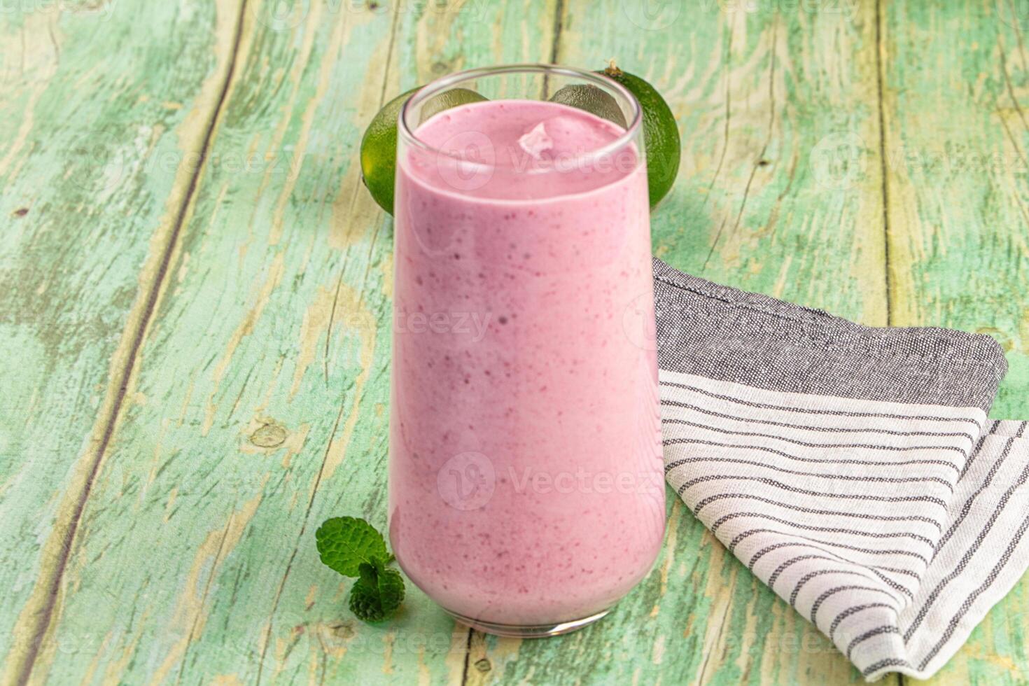 A pink smoothie in a glass on a wooden table photo