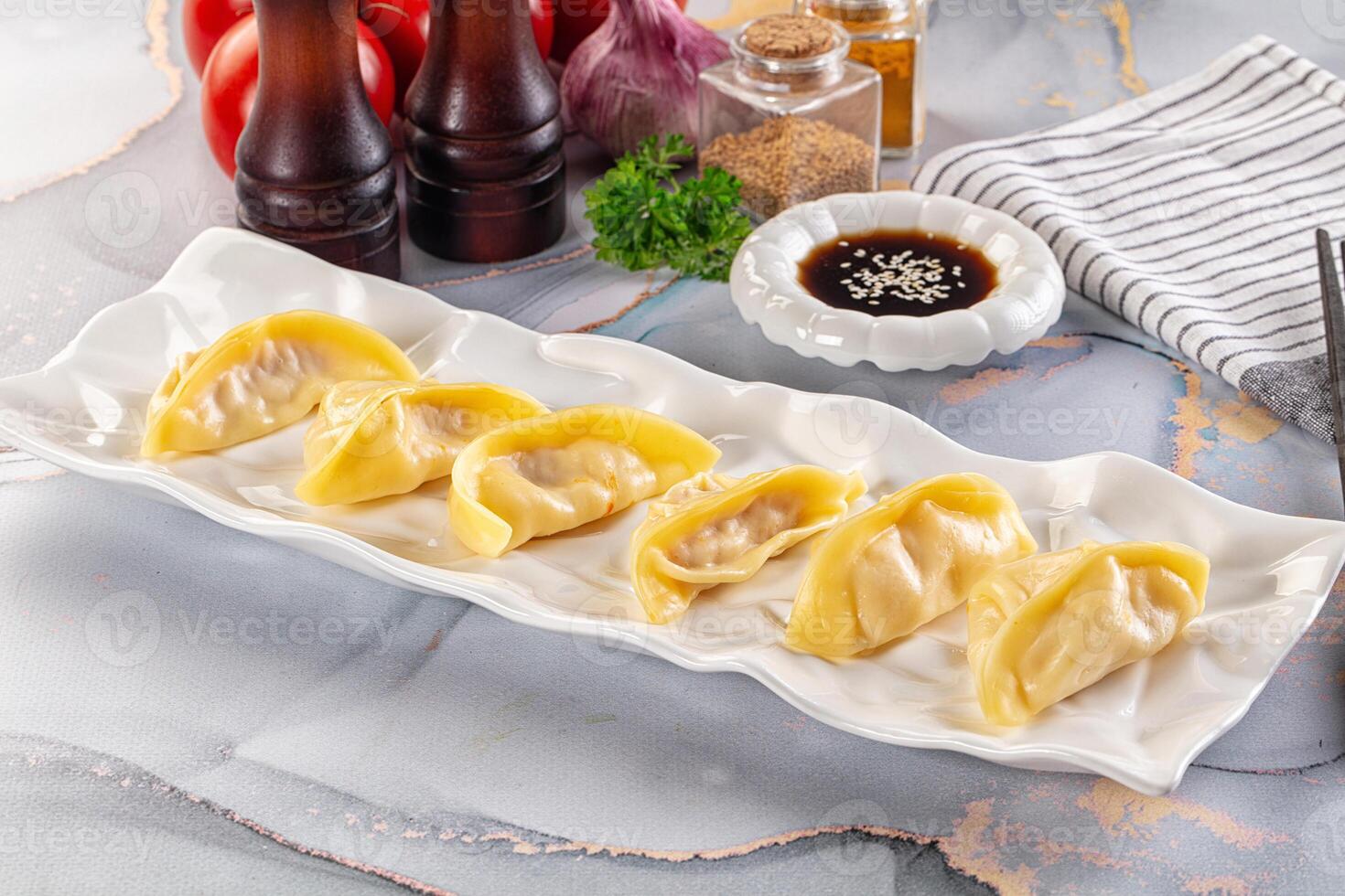 A plate with dumplings on it and some spices photo