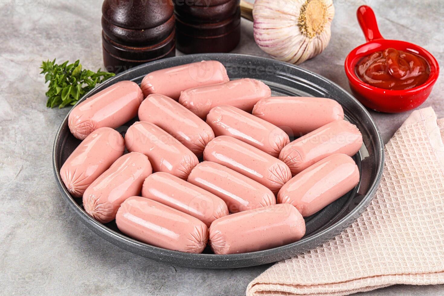 A plate of sausages on a table with garlic and other spices photo