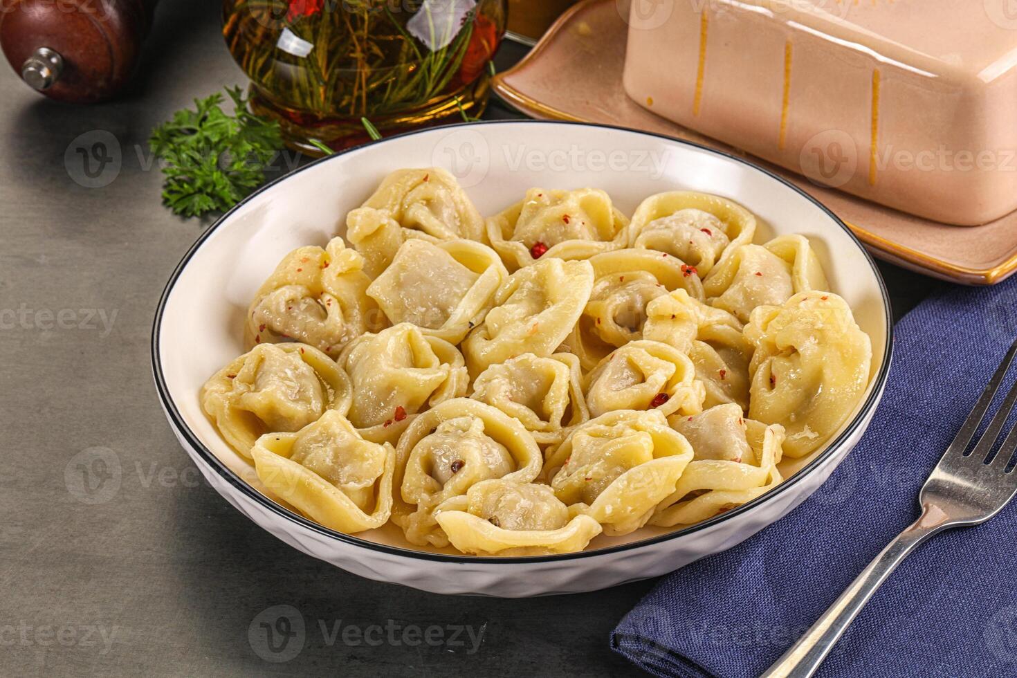 A bowl of pasta with meat and cheese on a table photo