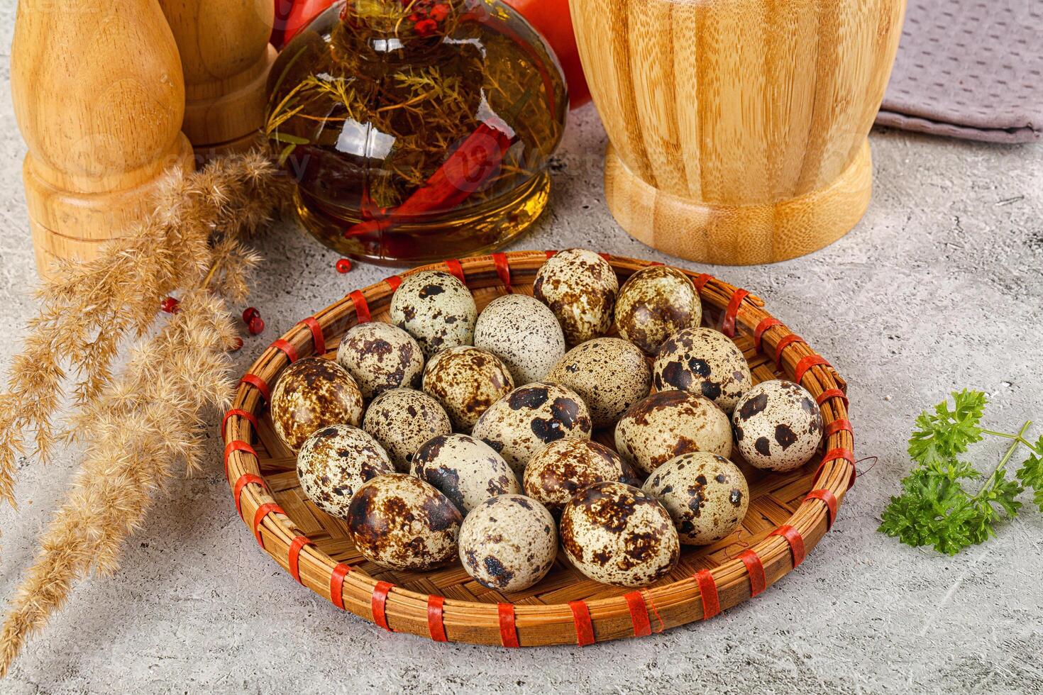 A basket of quail eggs on a table next to a bottle of olive oil photo