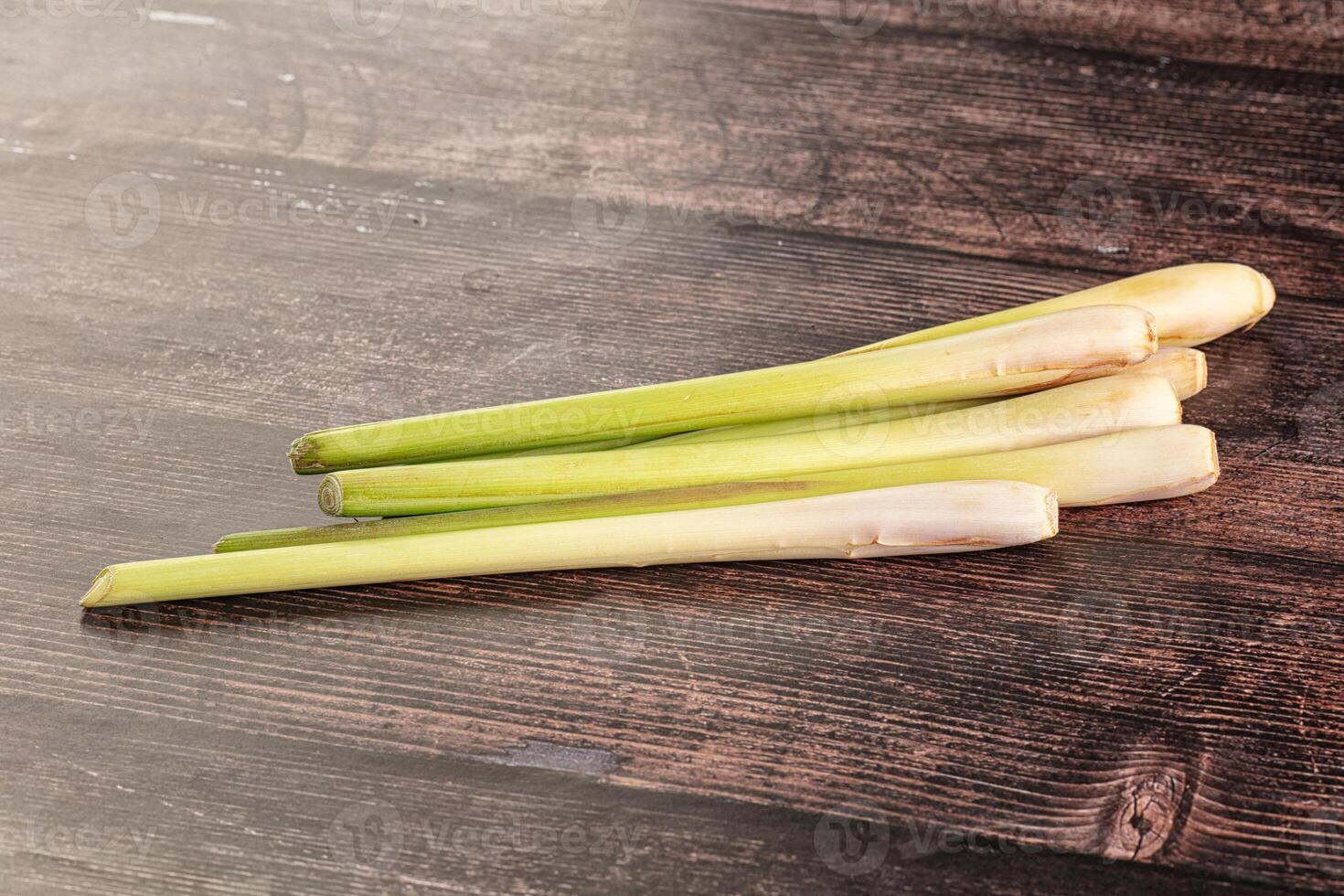 A pile of fresh green leeks on a wooden table photo