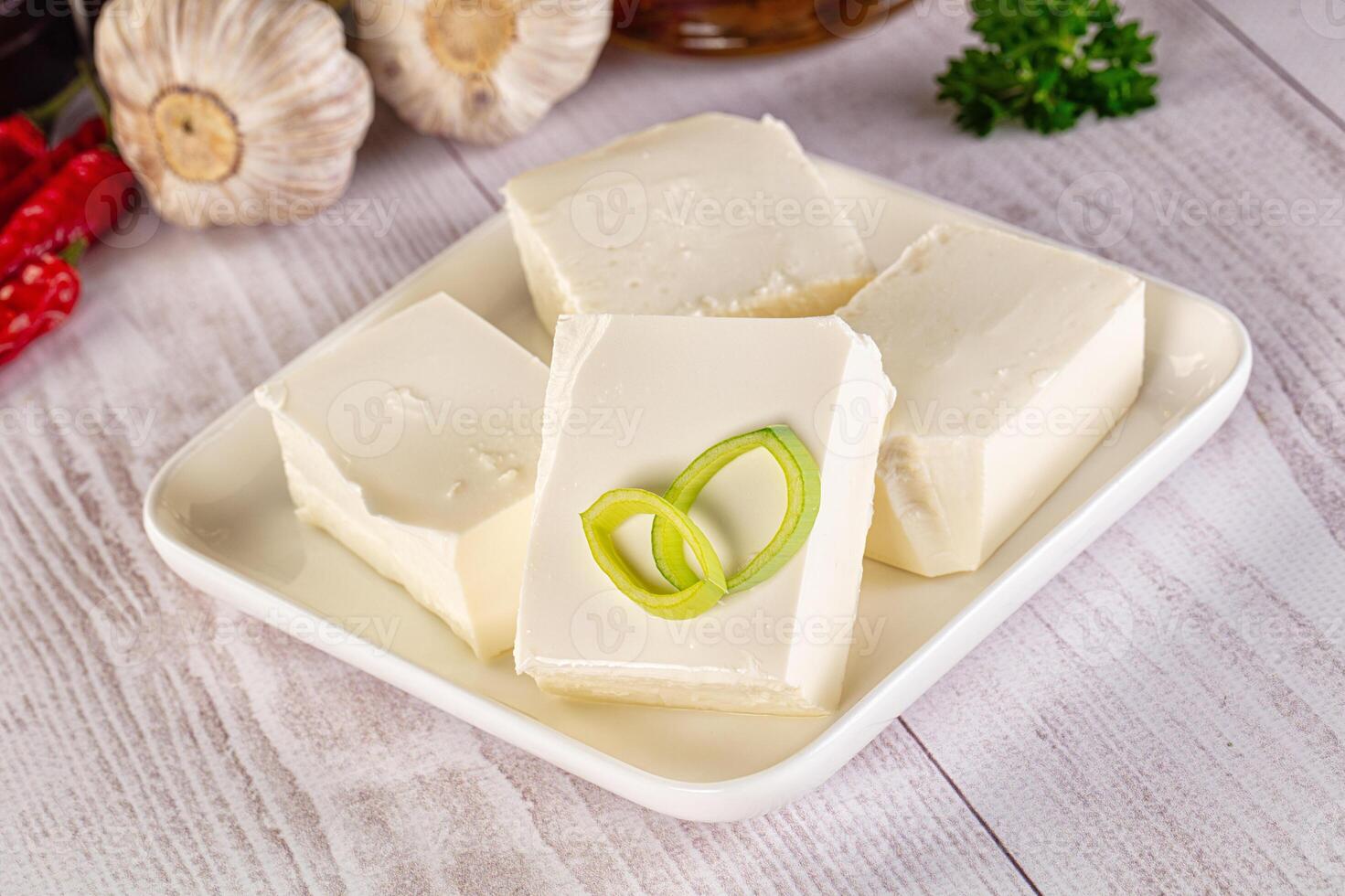 A plate with four pieces of tofu and garlic photo