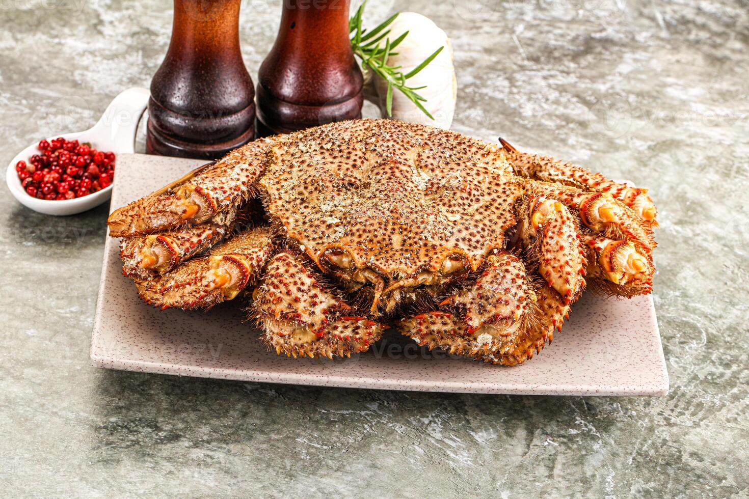 A large crab on a plate with a bottle of beer photo