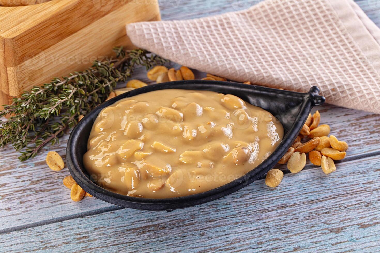 Peanut butter in a bowl with a towel and herbs photo