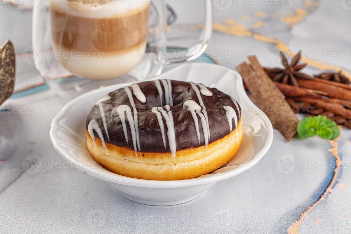 A cup of coffee and a donut on a table photo