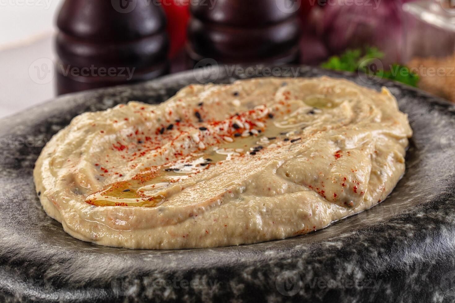 A bowl of hummus with a side of garlic photo