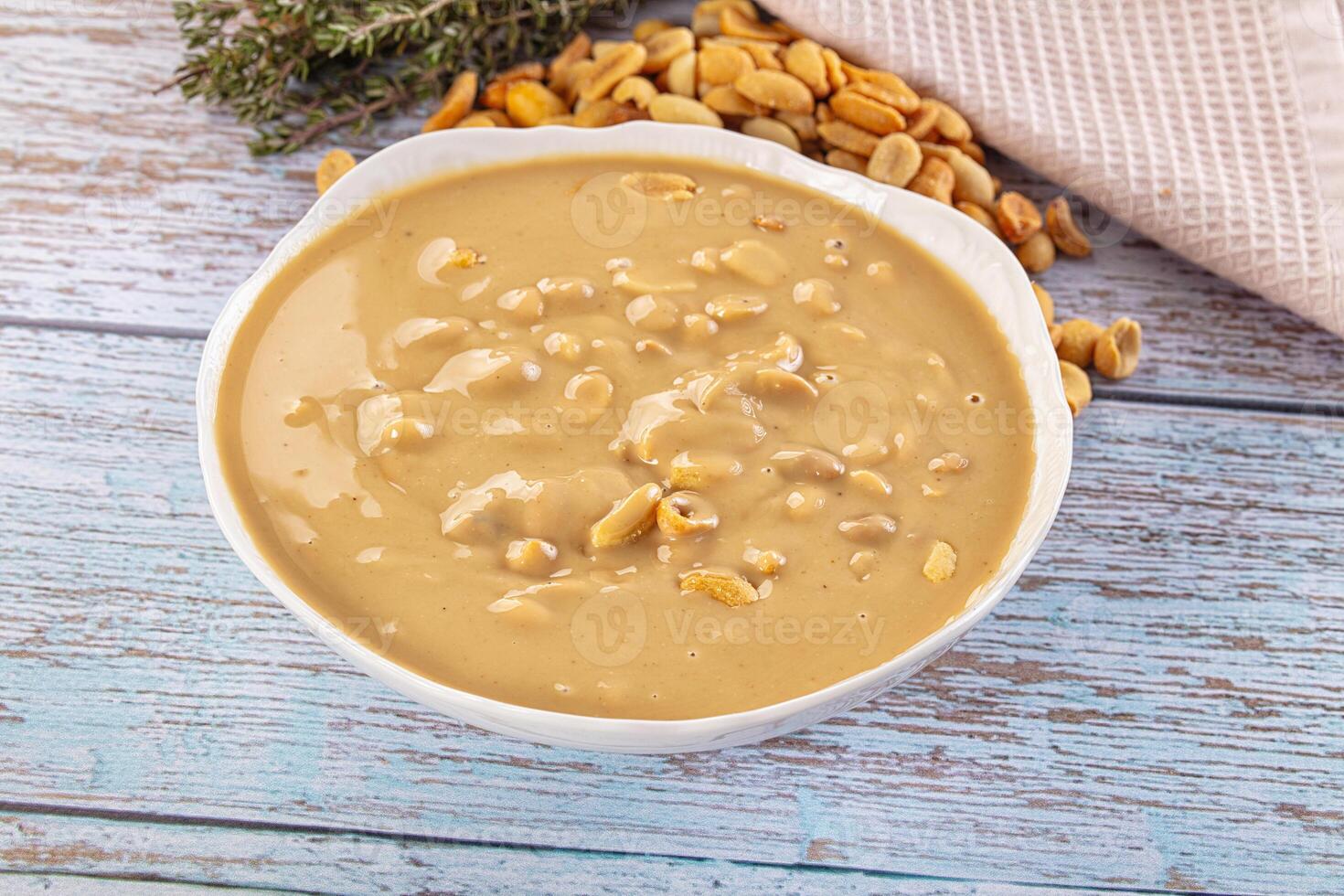 A bowl of peanut butter and nuts on a table photo