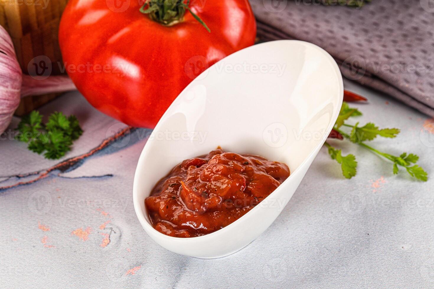 A white spoon with tomato sauce on it photo
