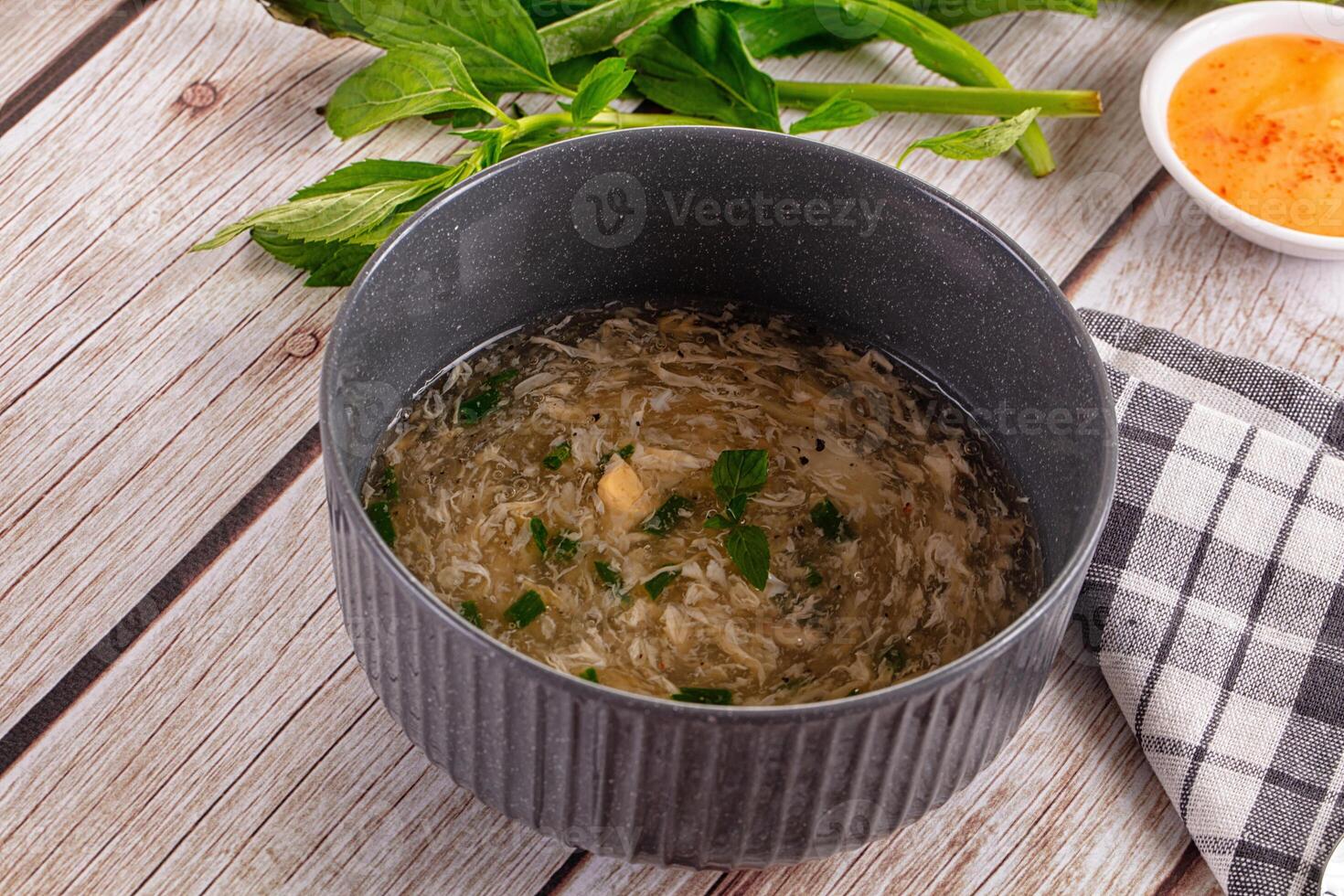 A bowl of soup on a table next to a bowl of soup photo
