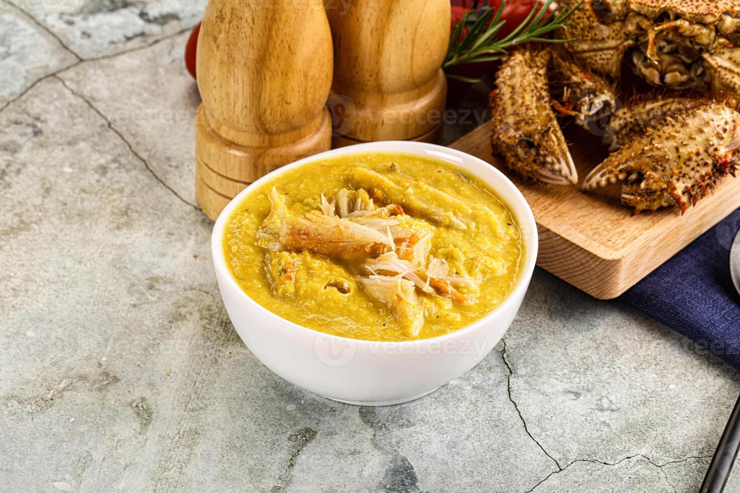 A bowl of soup with a spoon and some bread photo