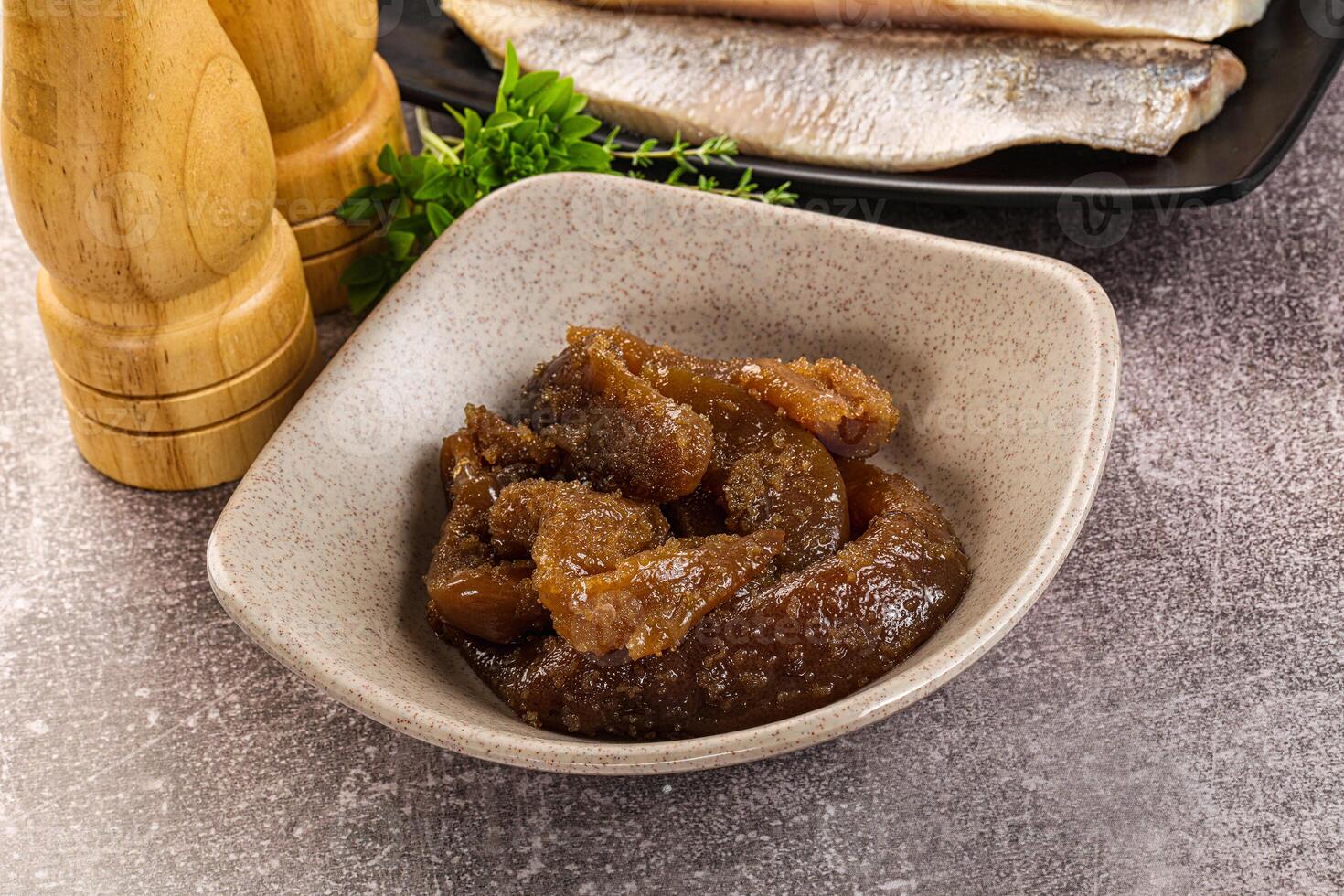 A bowl of meat and a wooden spoon next to it photo
