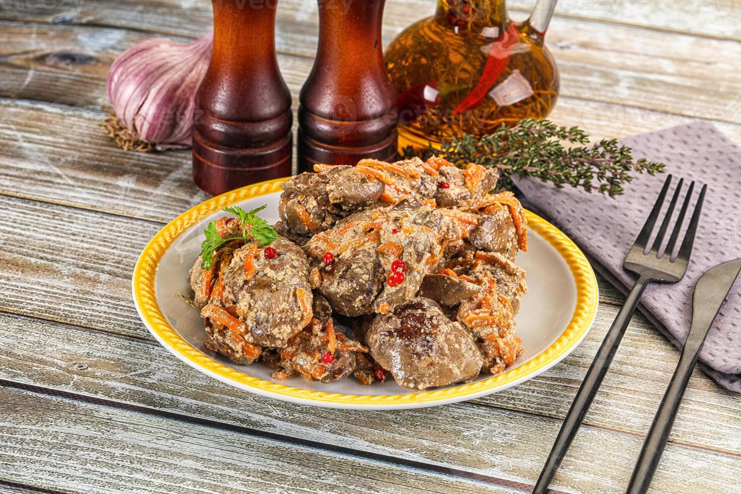 A plate of meat with vegetables on a wooden table photo