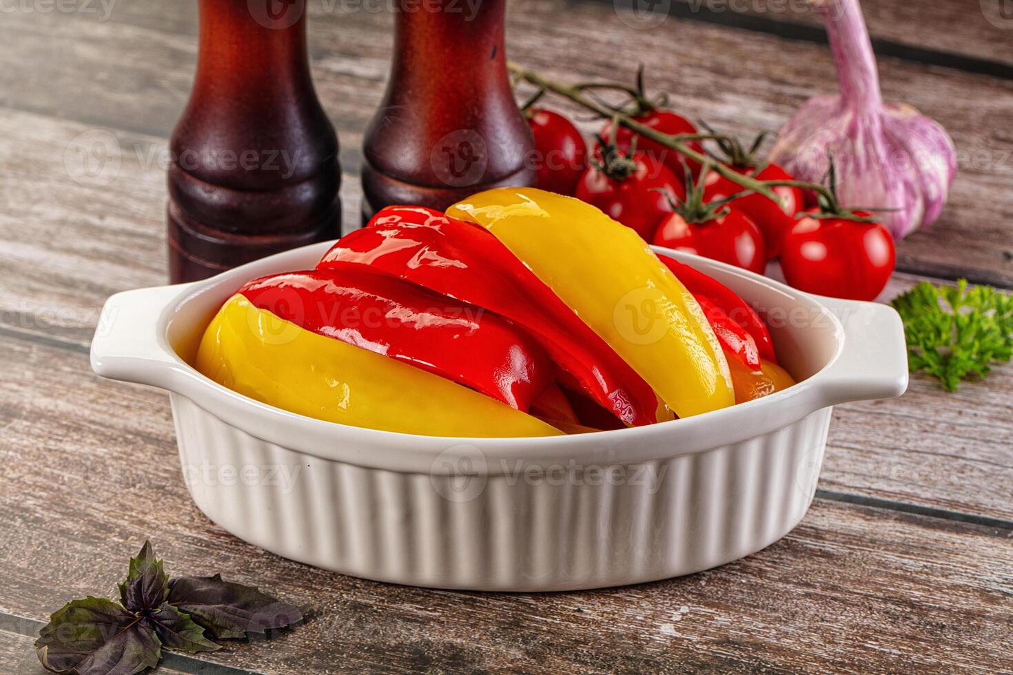 A bowl filled with peppers and tomatoes on a table photo