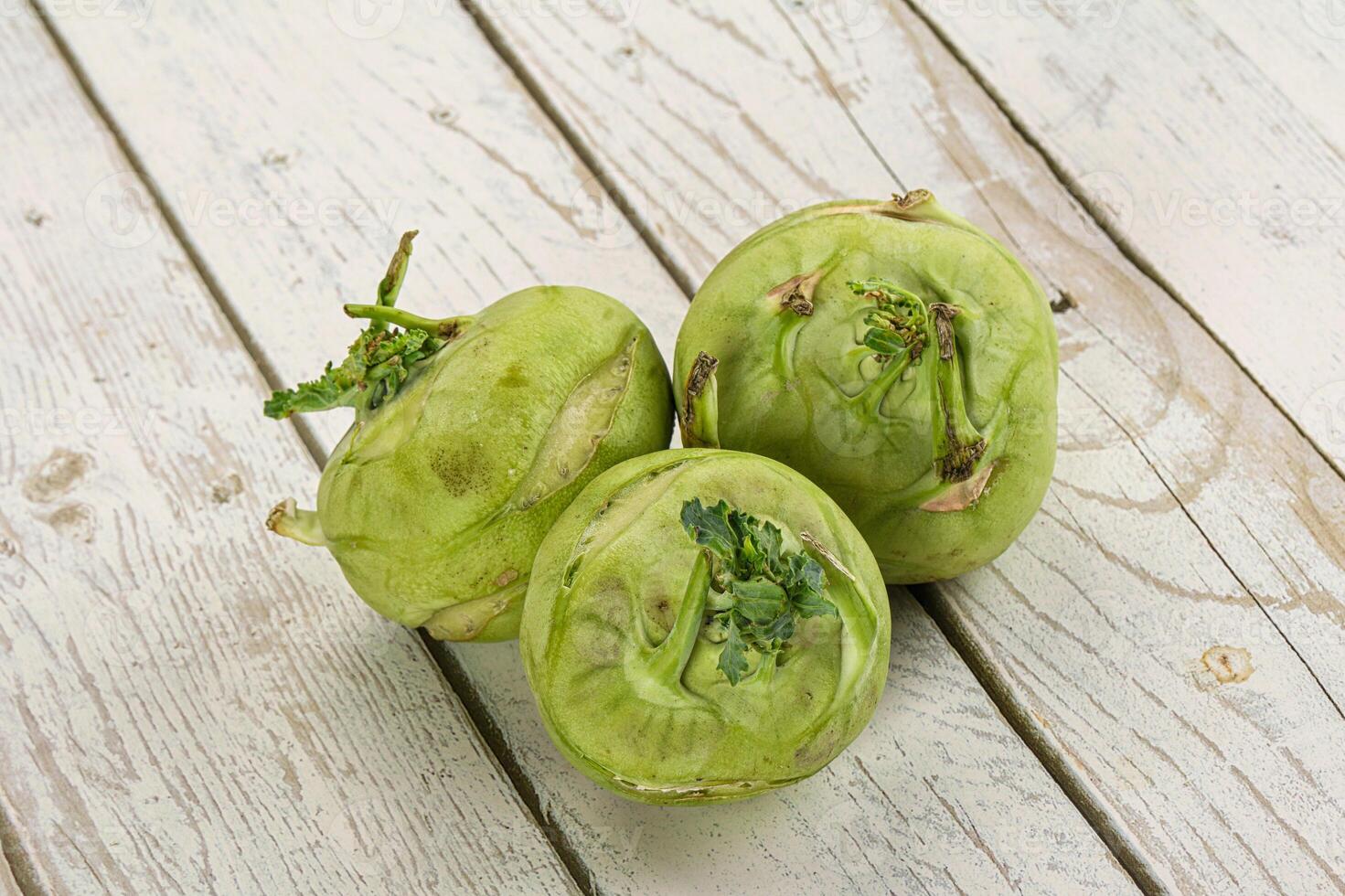 Three green artichokes on a white wooden table photo