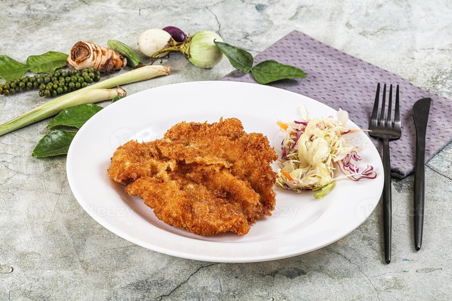 Fried chicken cutlet with slaw and vegetables photo