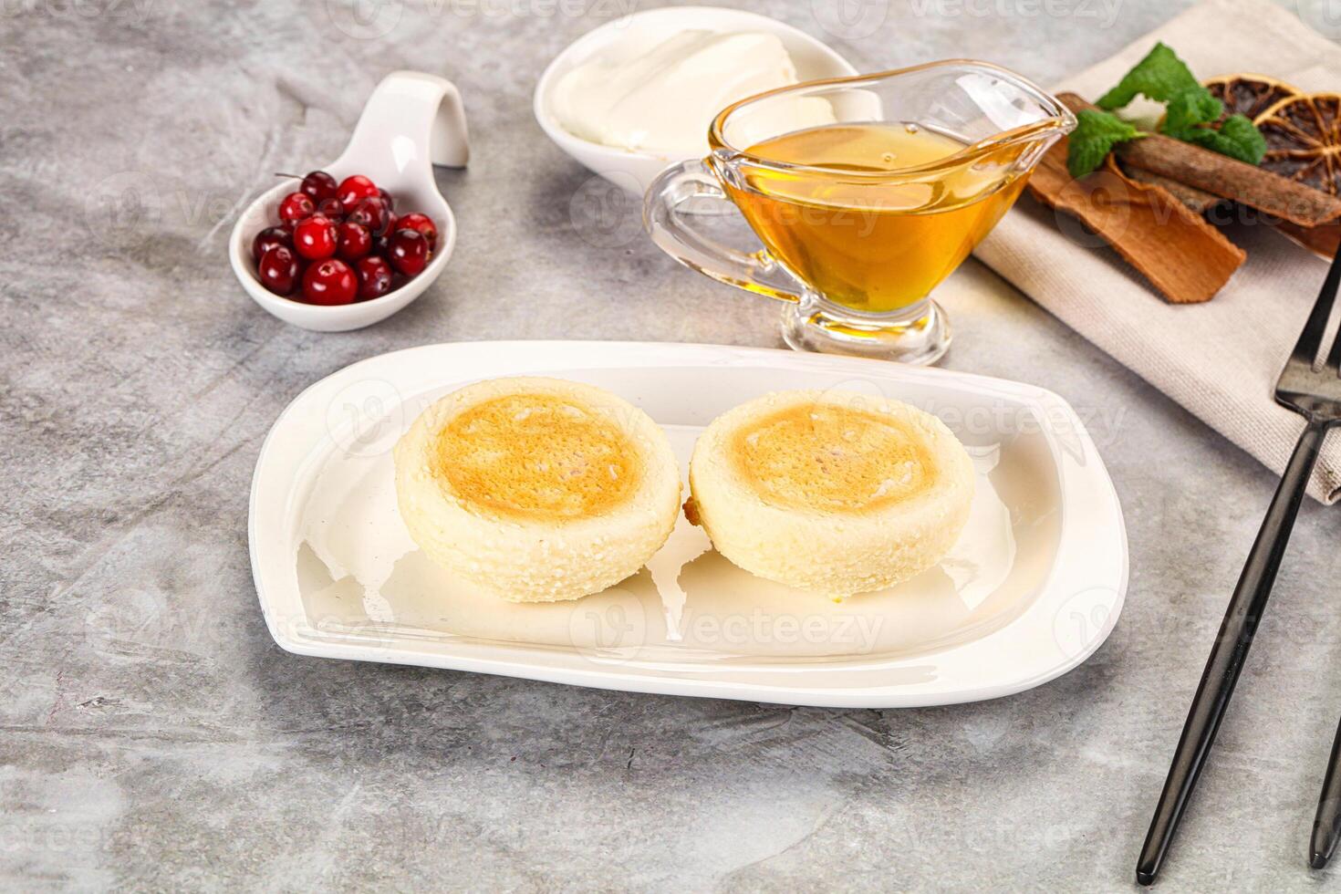 A plate with two cakes on it and a cup of tea photo
