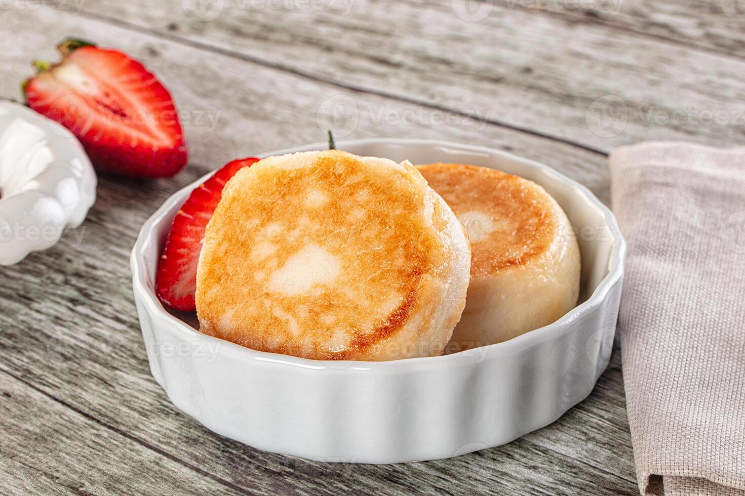 A bowl of pancakes and strawberries on a table photo