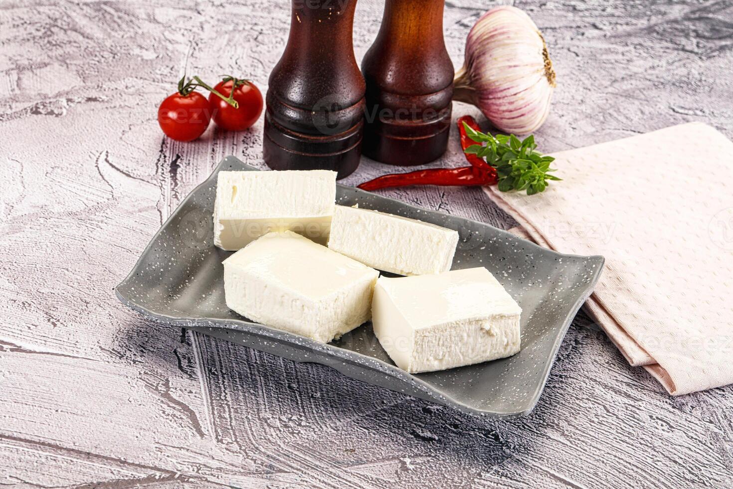 A plate with some cubes of cheese and some tomatoes photo