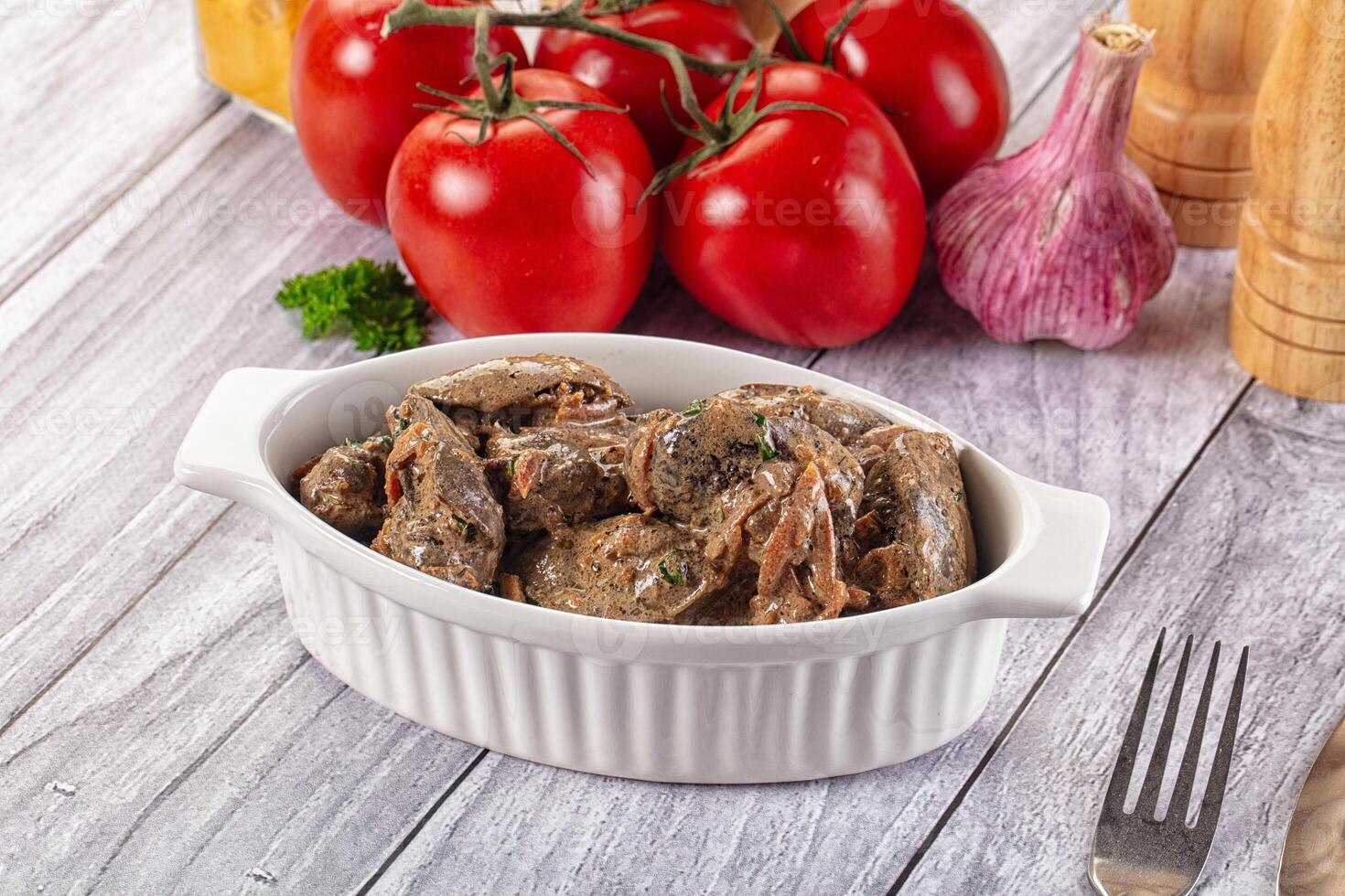 A bowl of meat with vegetables on a table photo