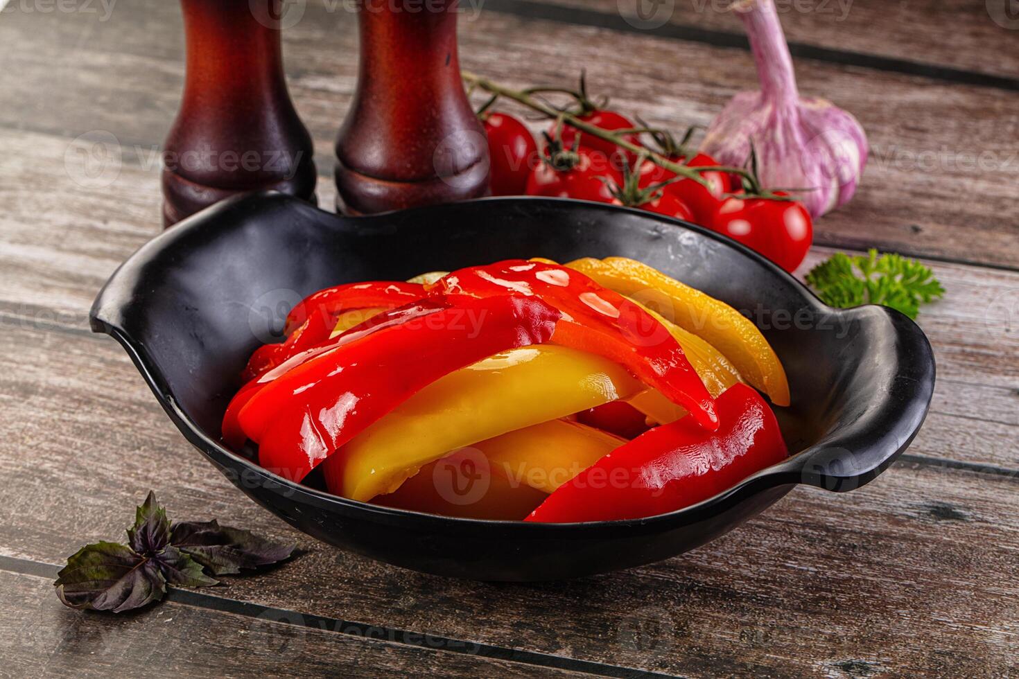A bowl of peppers and onions sitting on a table photo