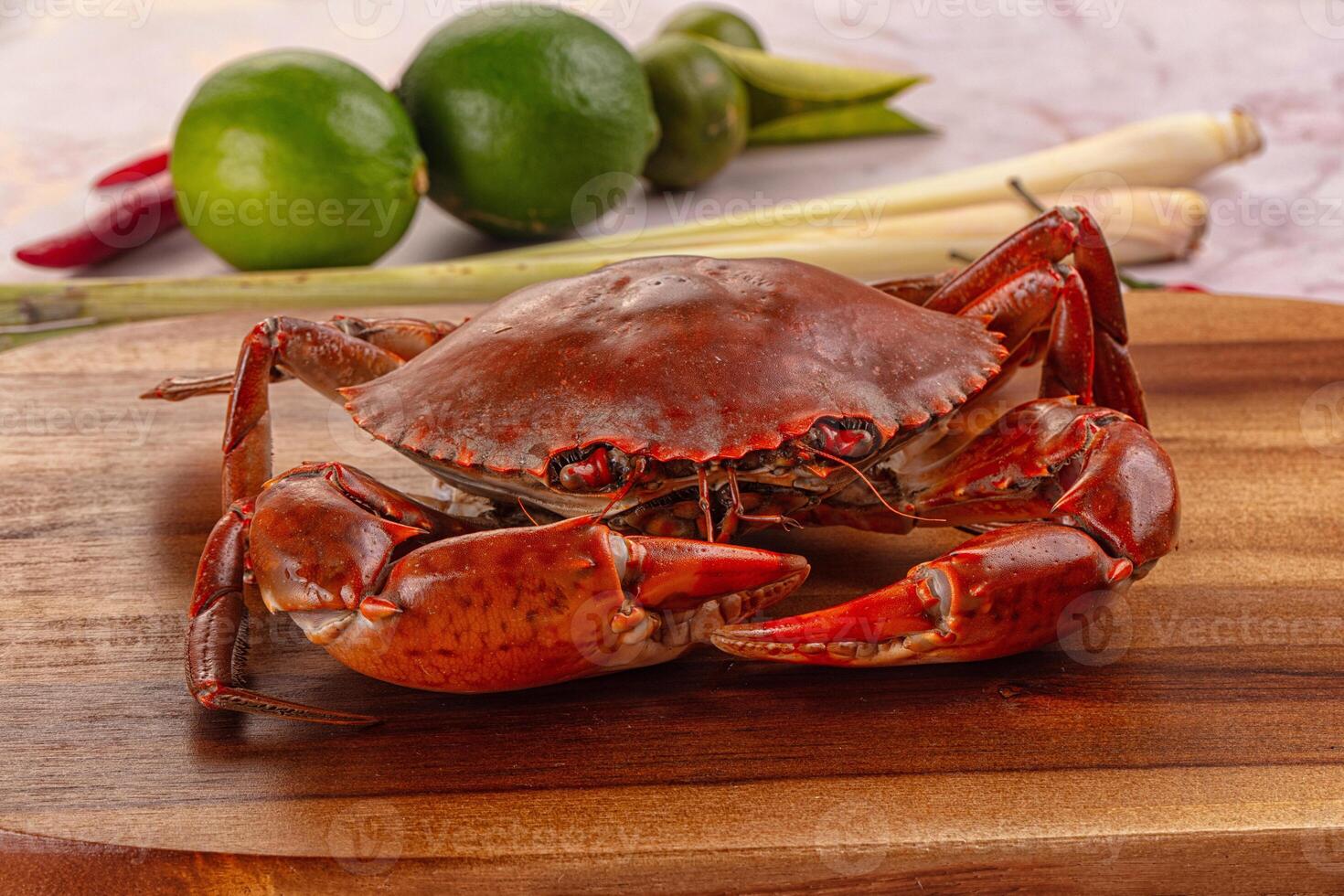 A crab sitting on a wooden cutting board photo