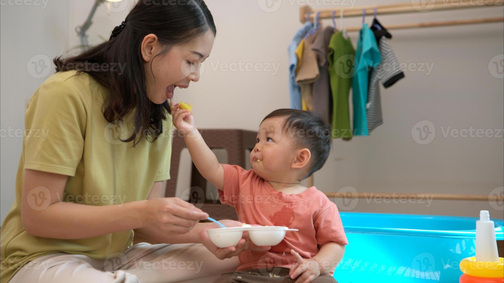 Little boy with breakfast with mom feeding him before bathing him,311 photo